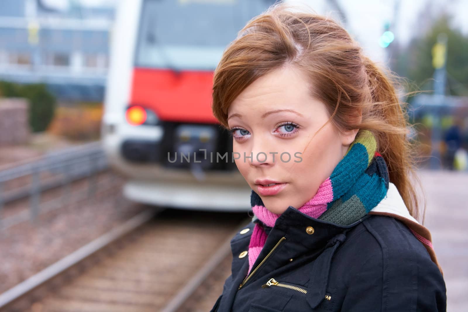 Teenage girl at railway platform, looking at camera