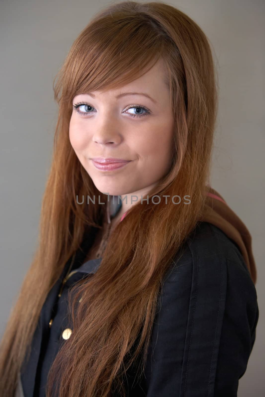 Teenage girl looking at camera smiling, interior