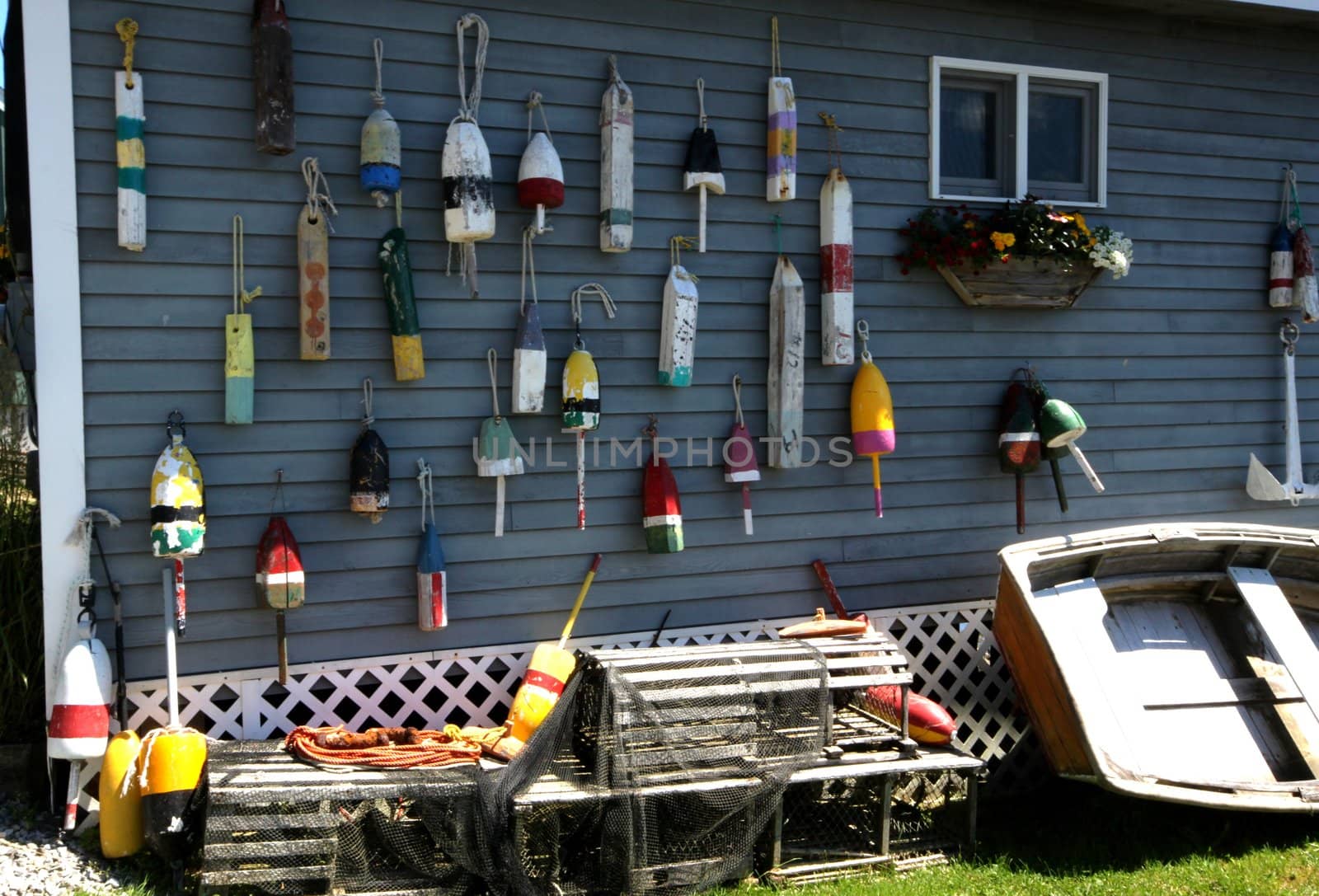 Series of lobster buoys hanging on the side of a boathouse