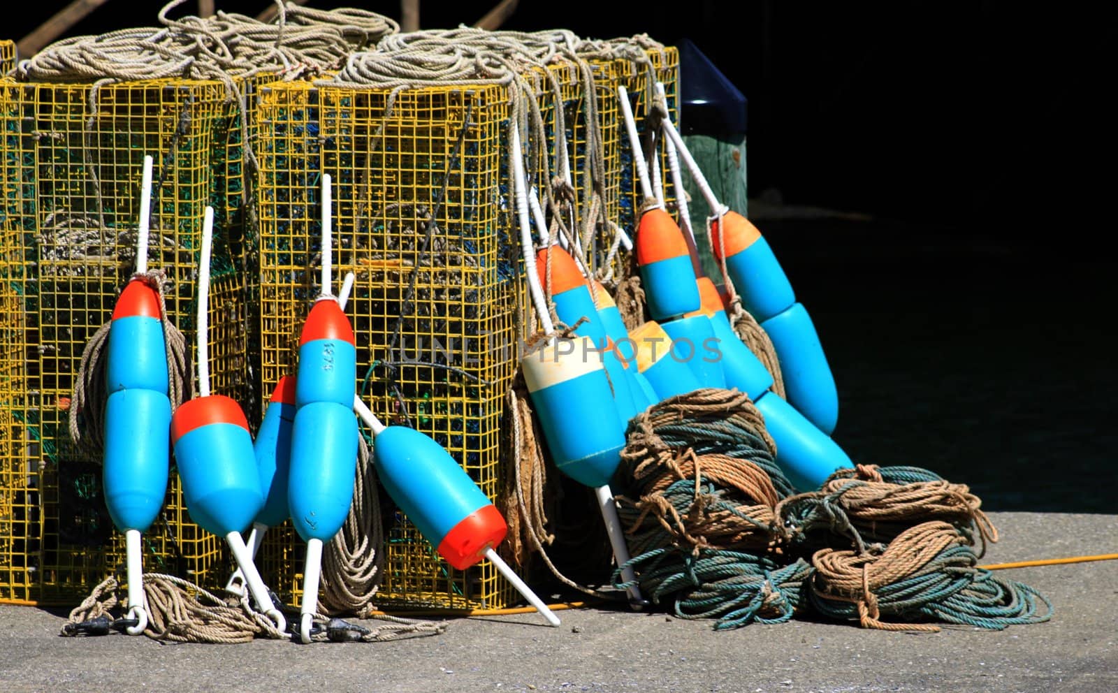 Lobster buoys leaning on cages on fishing wharf