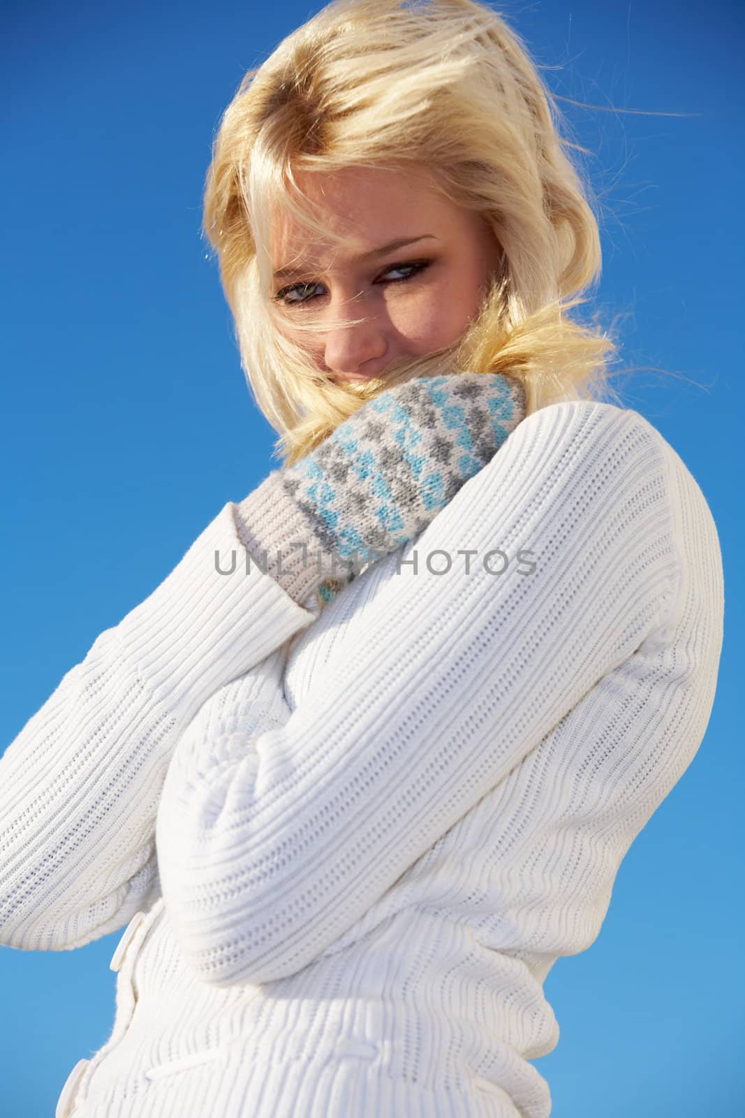 Teenage girl trying to keep herself warm, looking at camera