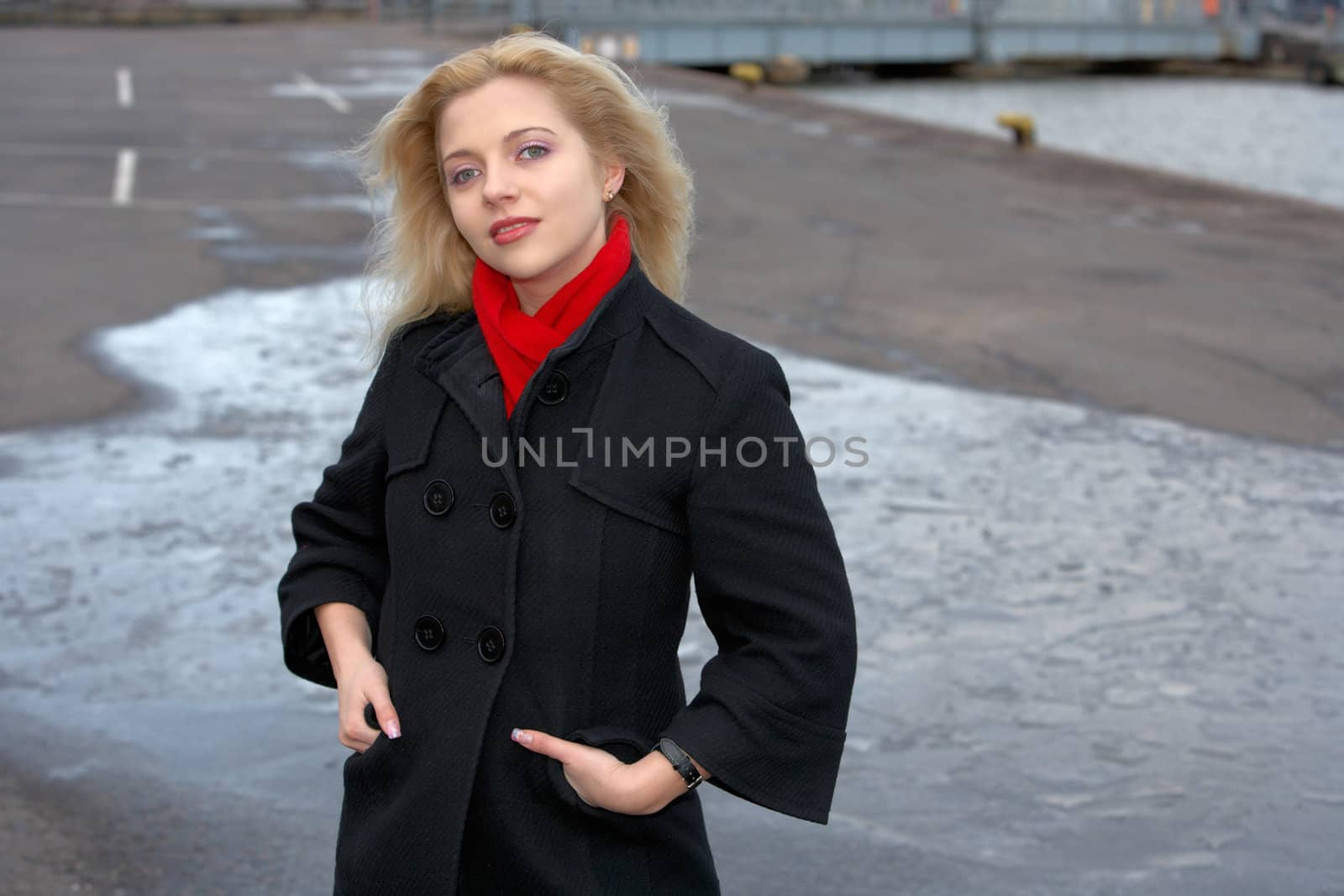 Young woman standing in harbor, hands in pockets