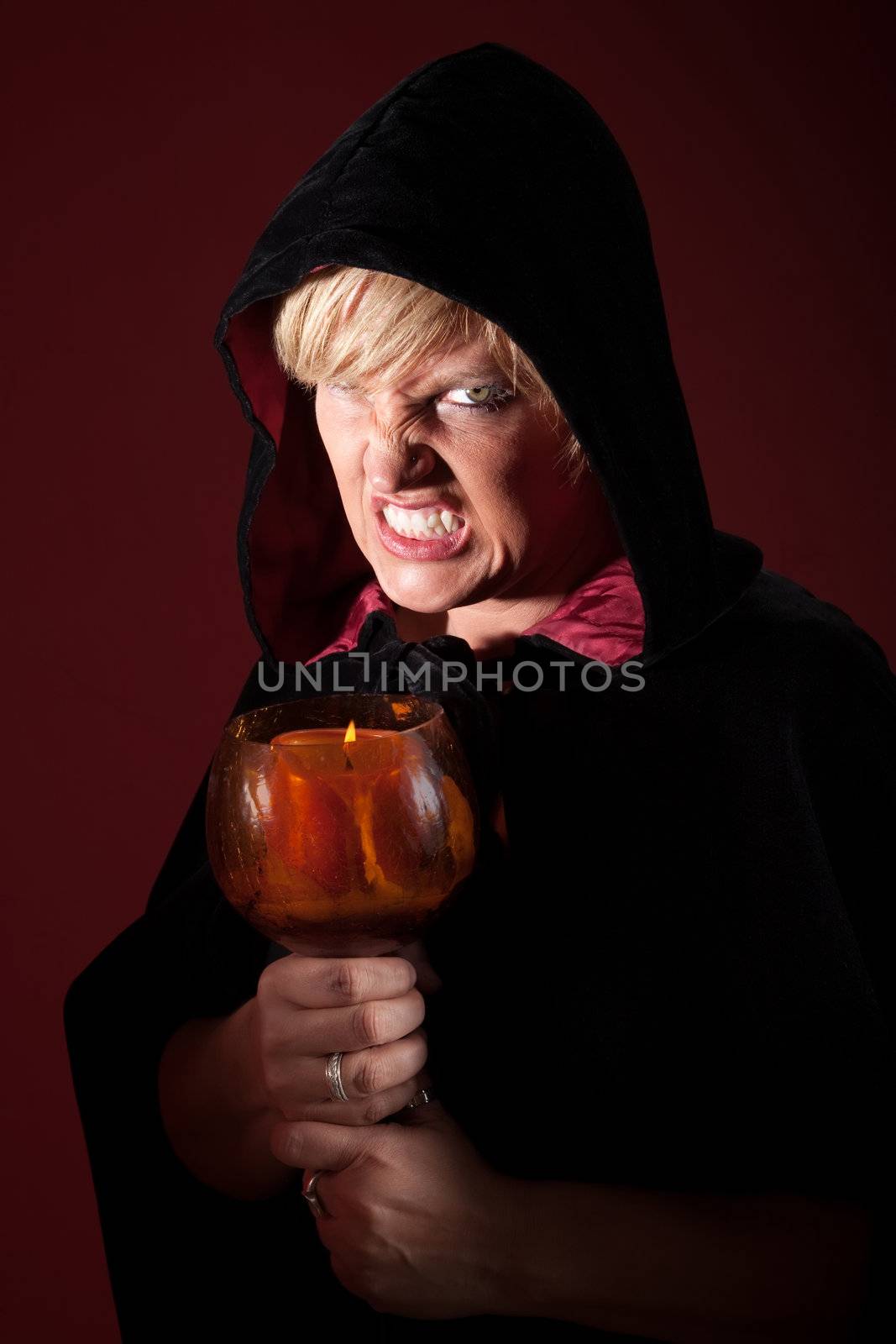Scary witch with teeth clenched and candle