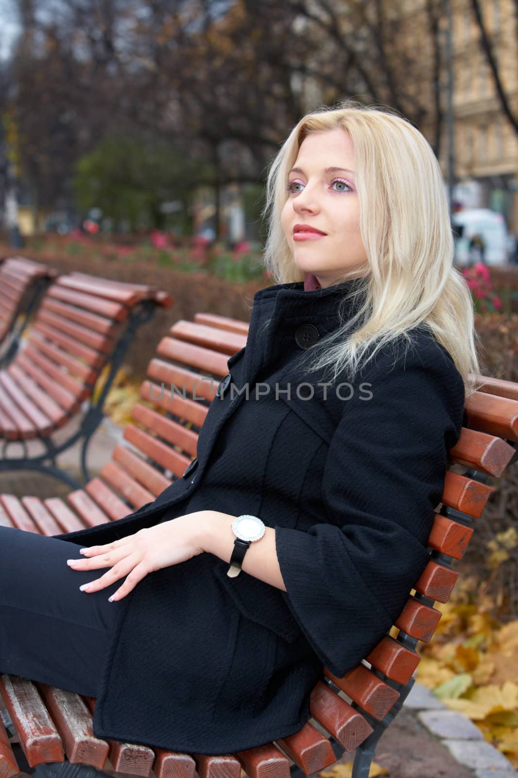 Young woman sitting on bench in park