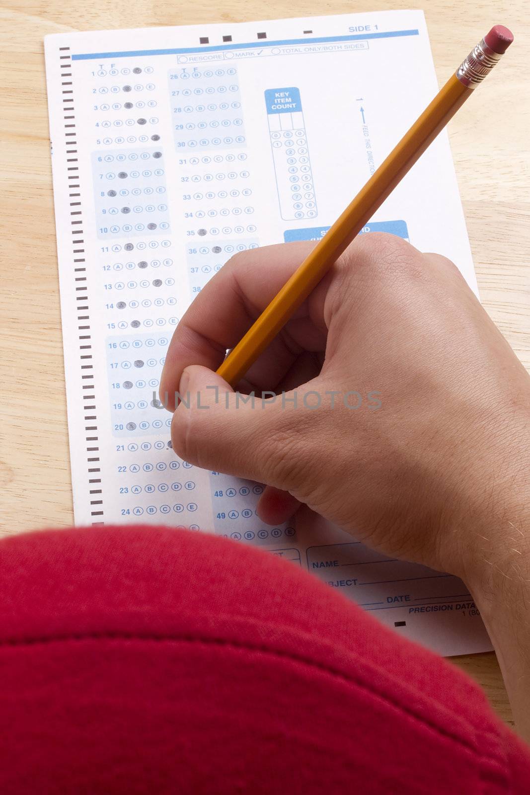 Student filling out answers to a test with a pencil.