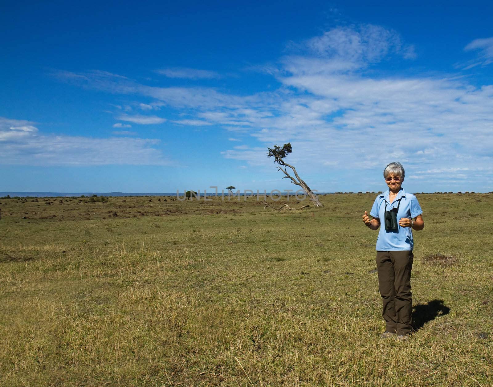 Woman standing alone on Masai Mara by SueRob