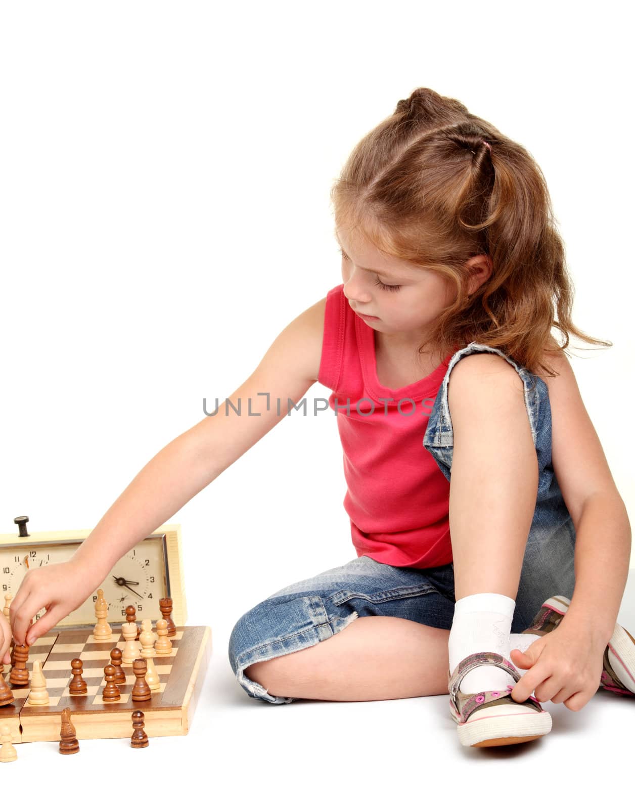 Little girl playing chess on the white background
