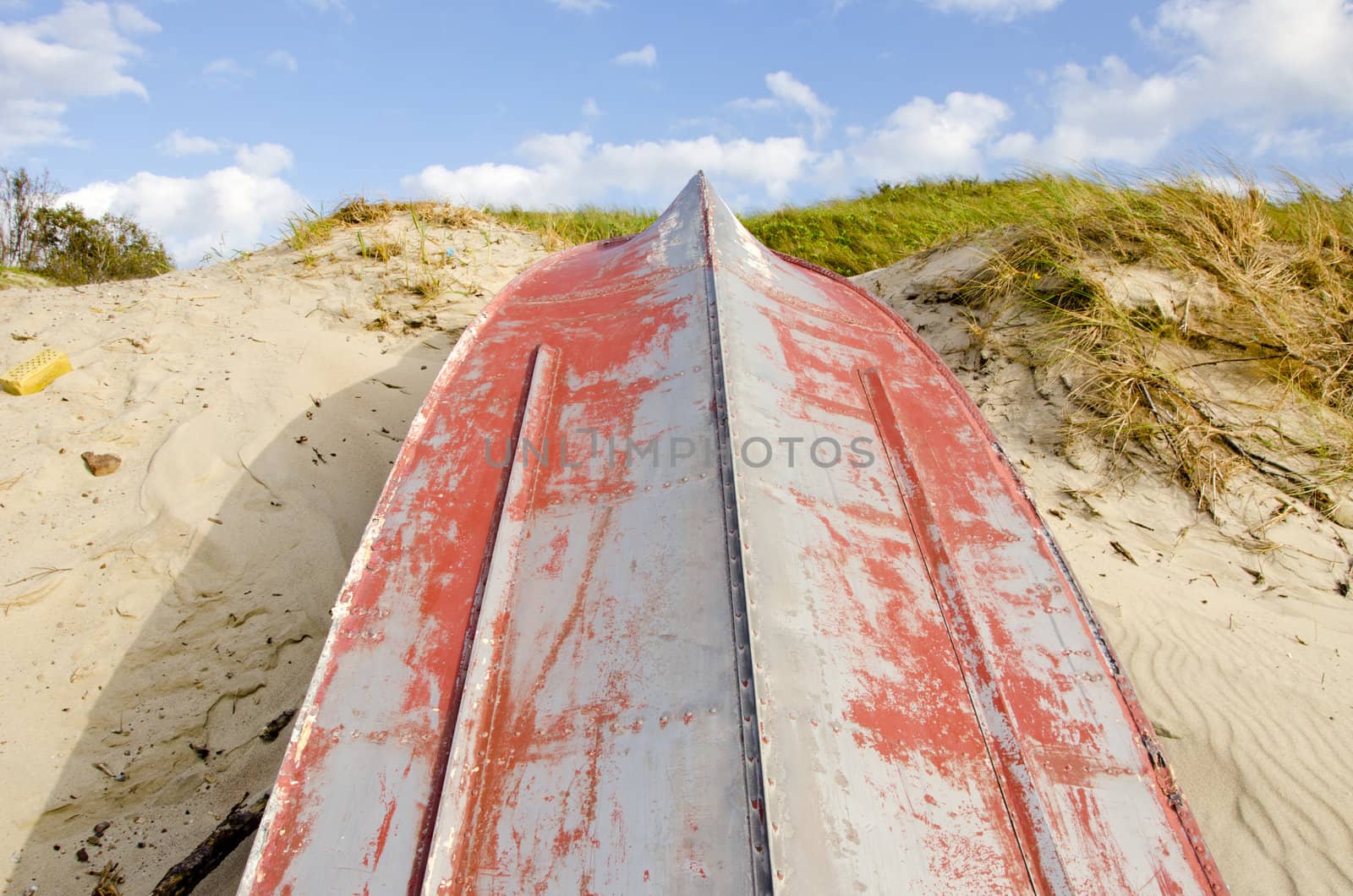 Boat made of tin upside down resting on the dunes. Water transportation.