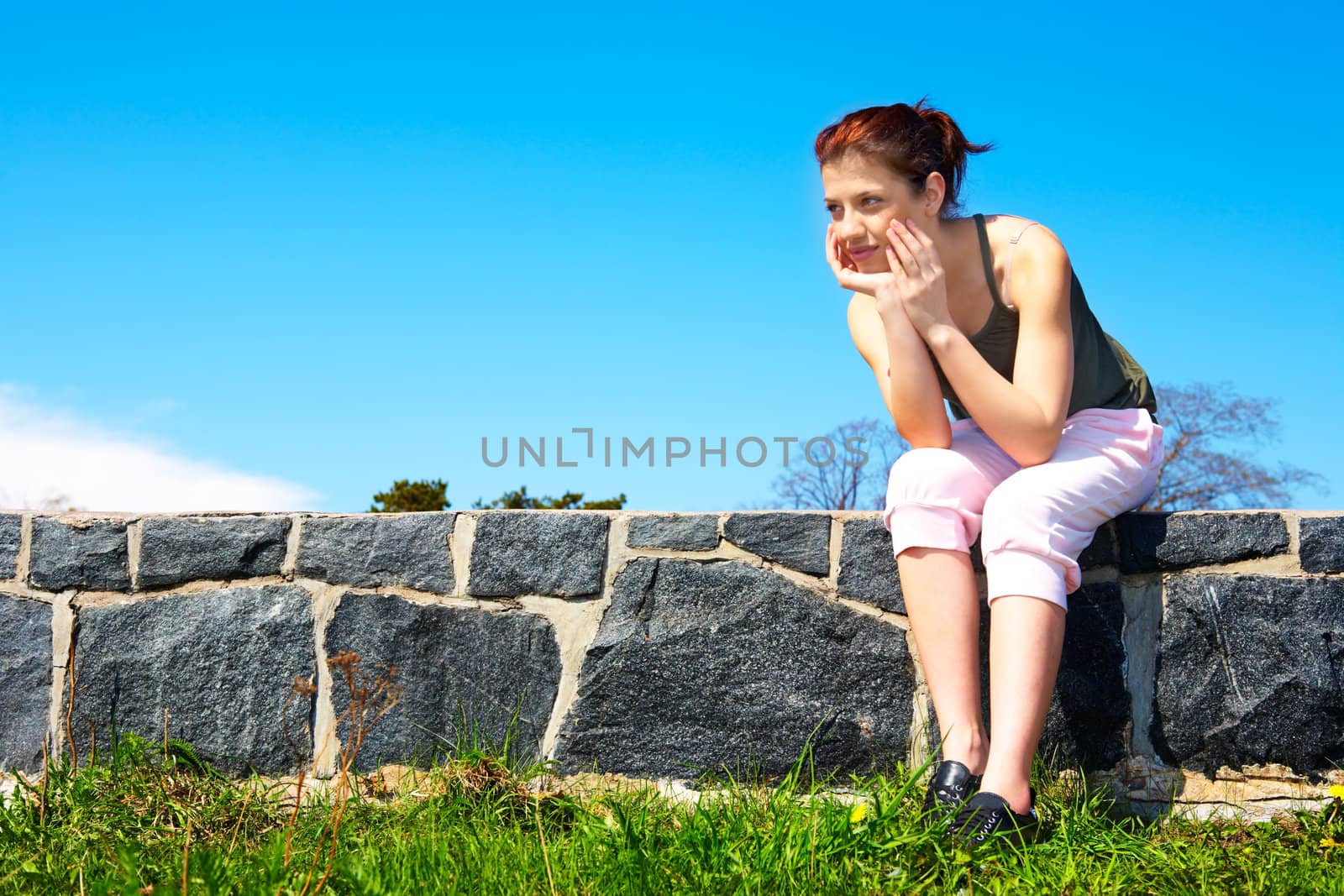 Teenage girl sitting wearing sportswear outdoors