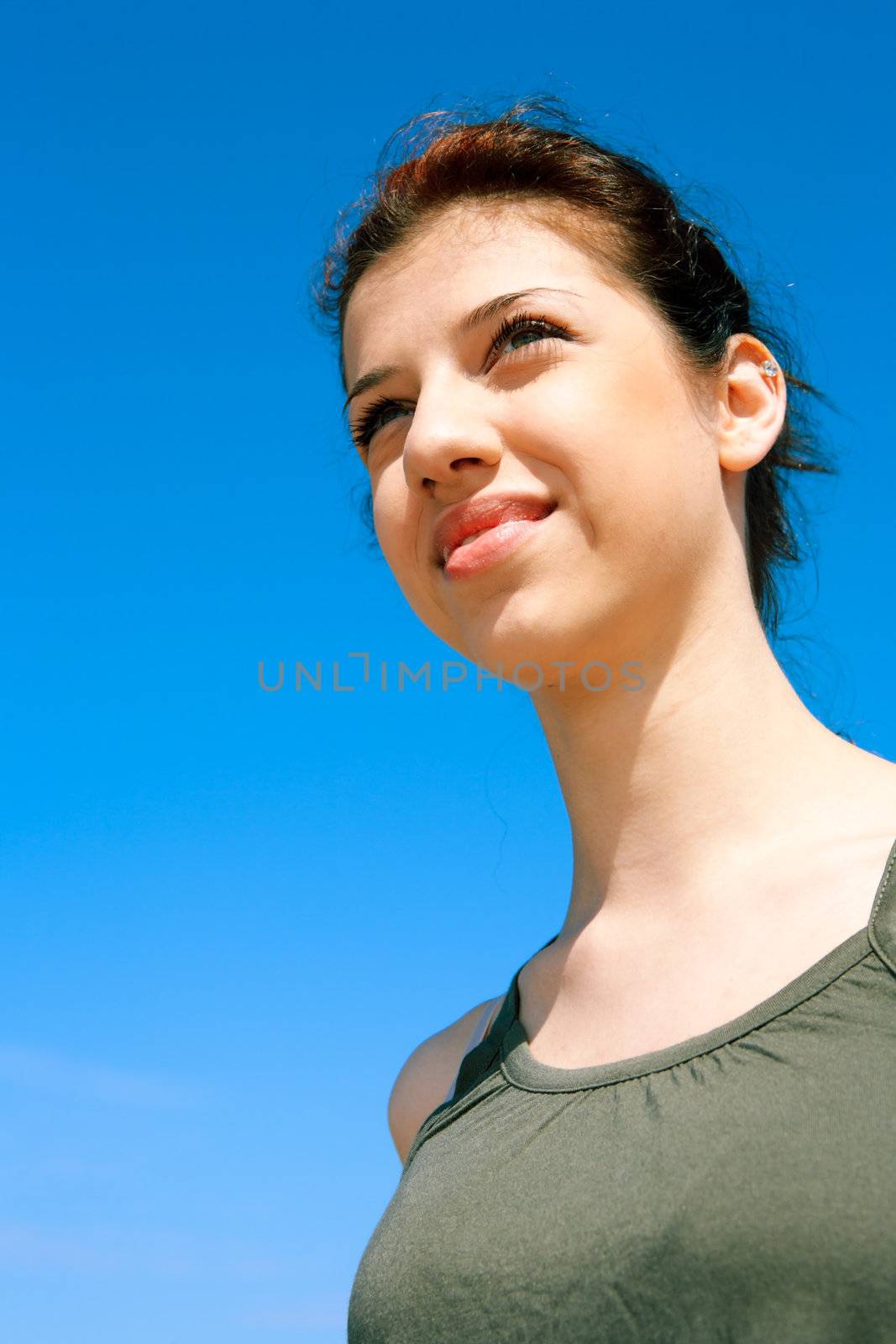 Teenage girl contemplating against blue sky