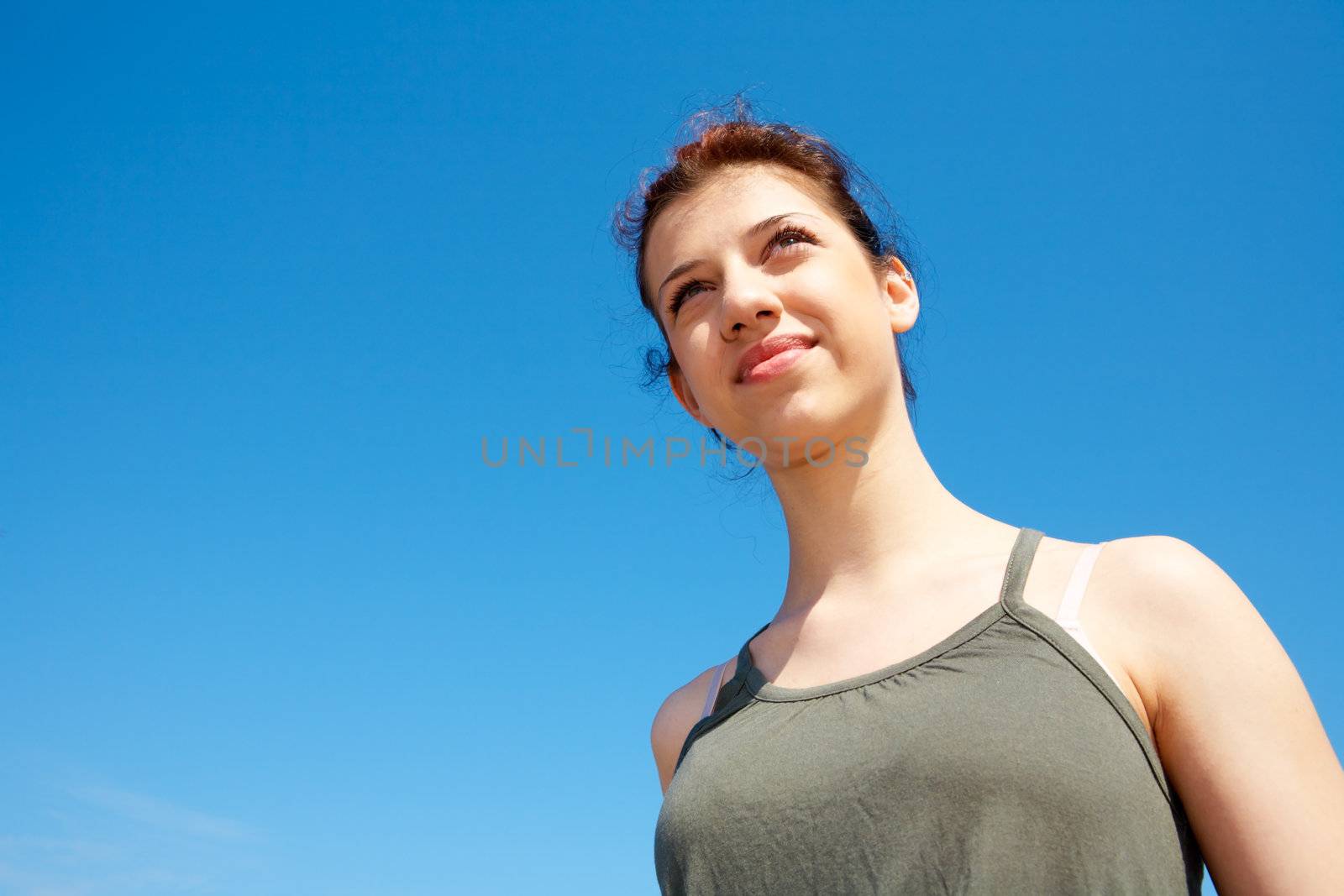 Teenage girl contemplating outdoors against blue sky
