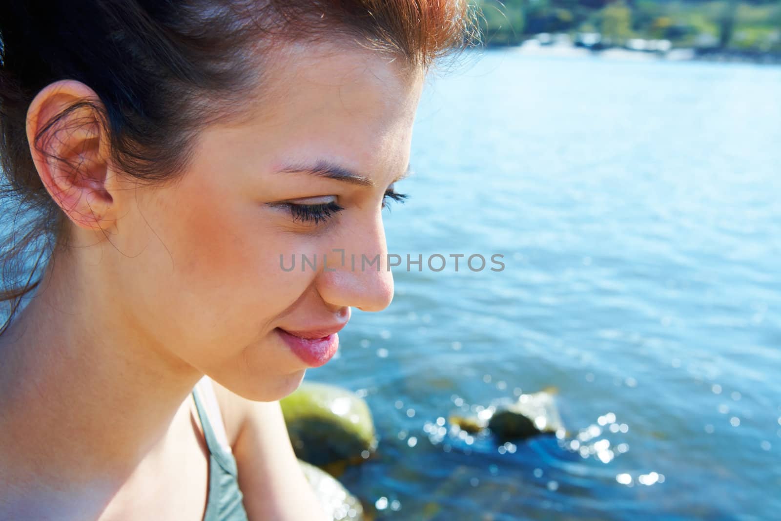 Teenage girl by sea on sunny day thinking