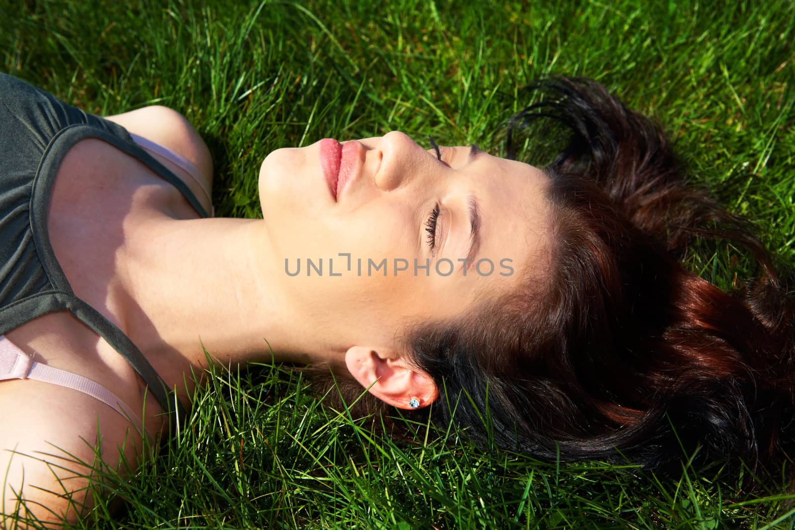 Teenage girl relaxing in grass eyes closed