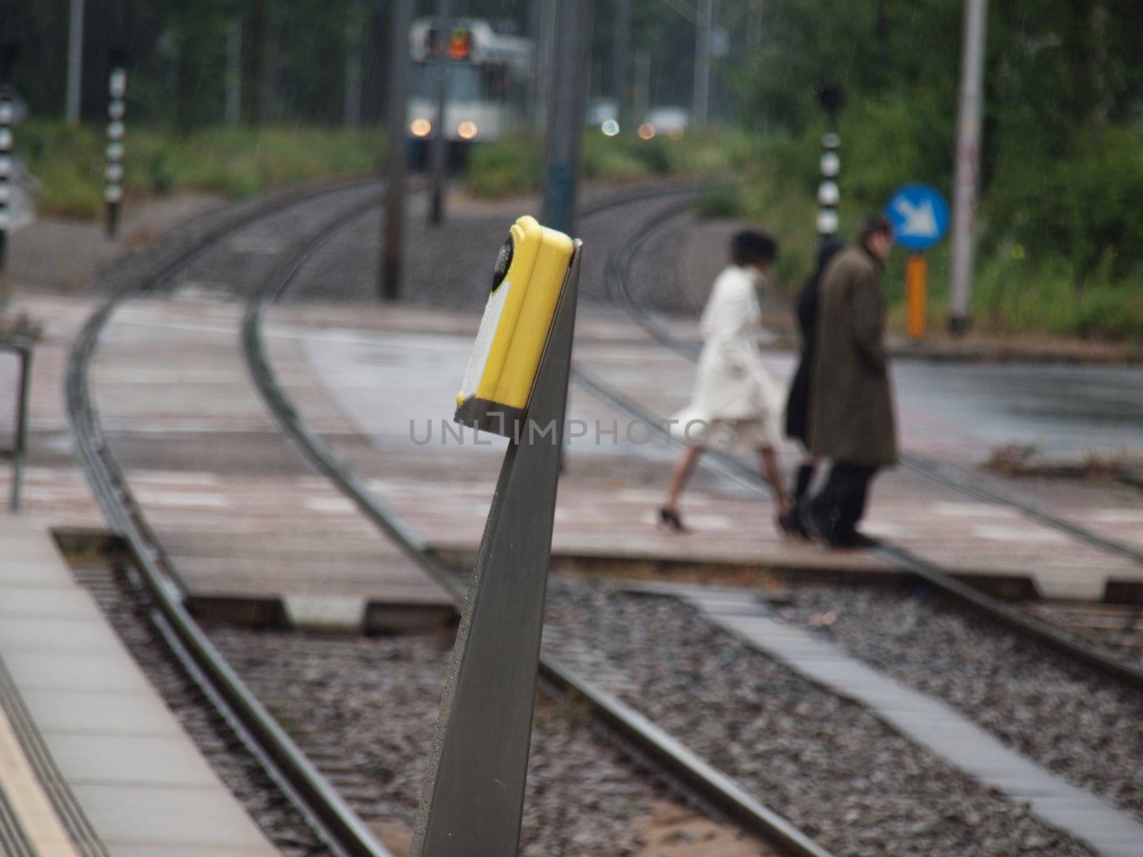 Tramway approaching station in Amsterdam in the Netherlands with pedestrians crossing