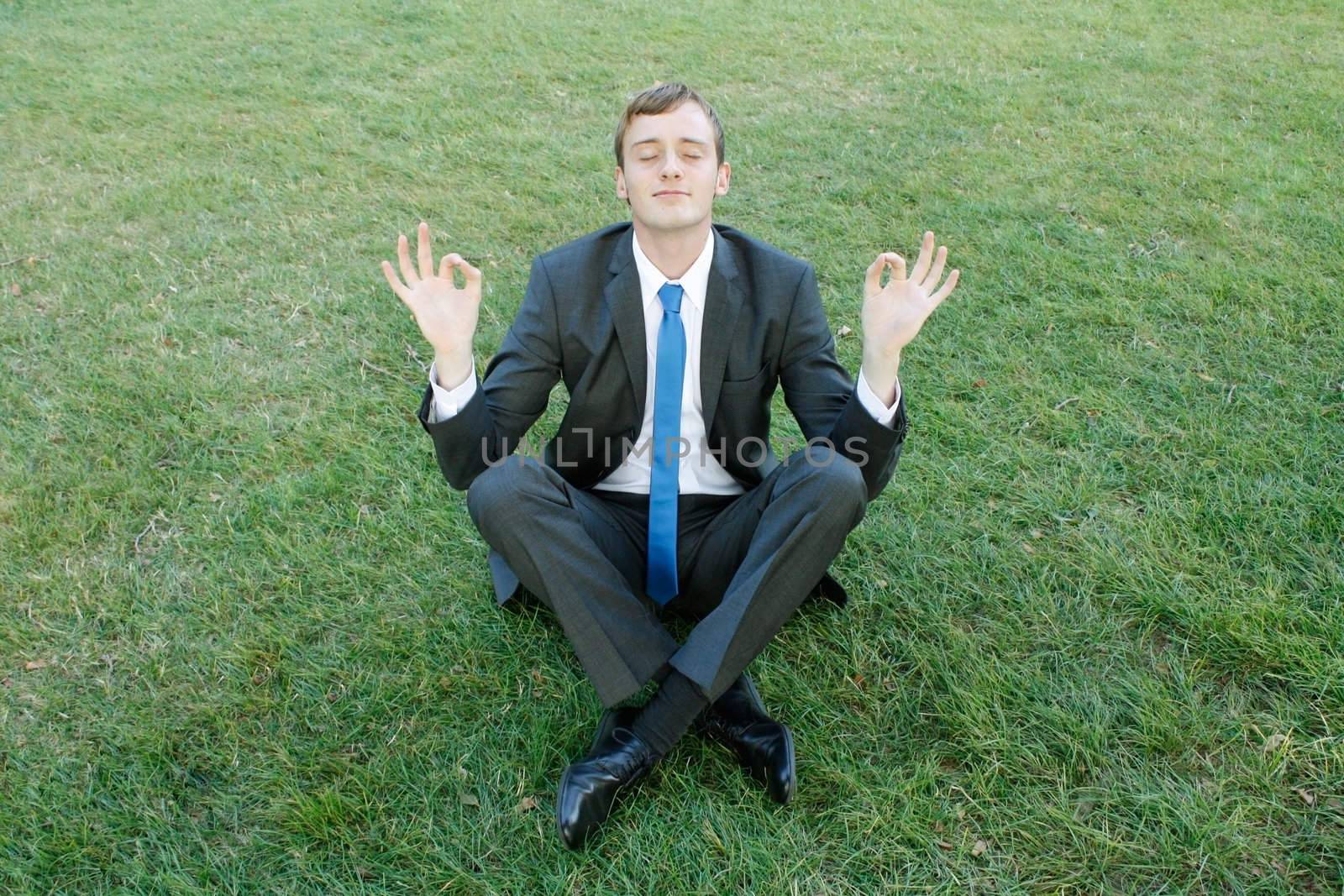 A business man doing yoga in the park
