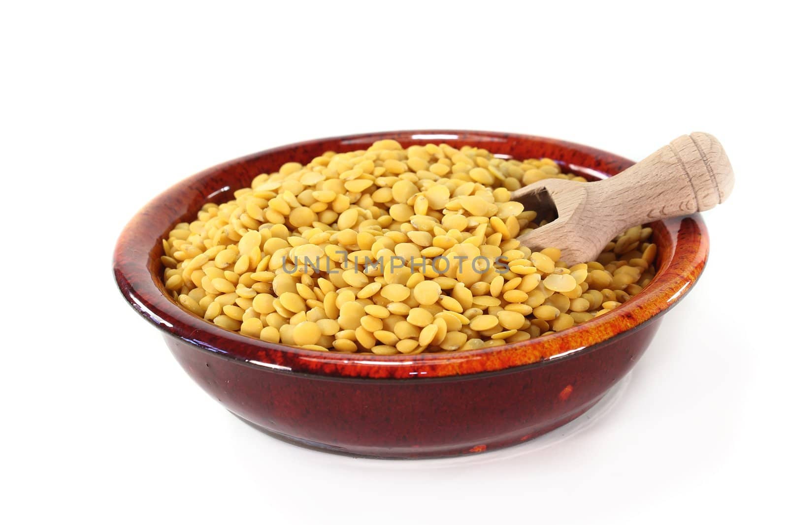 a red bowl with yellow lentils and shovel