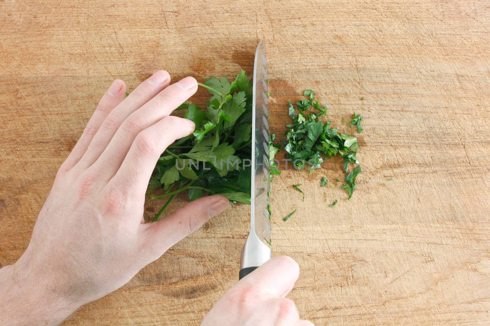 Chopping parsley on a wooden surface