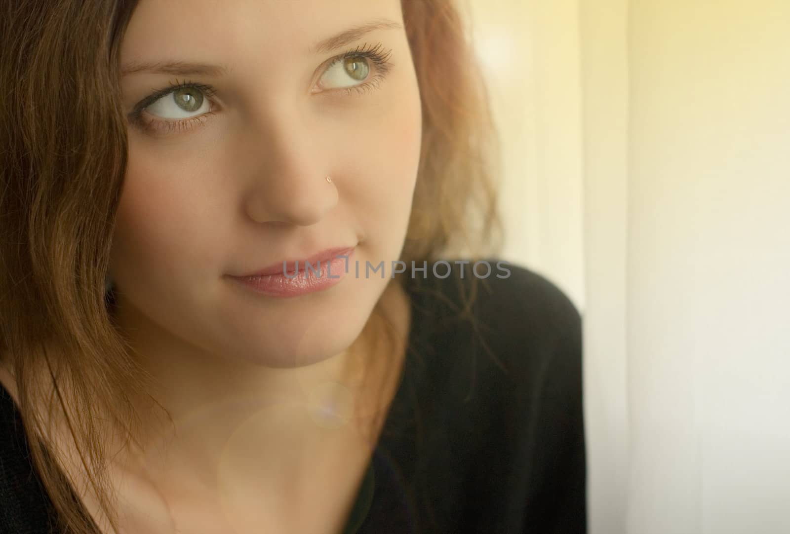Portrait of beautiful young woman near the window