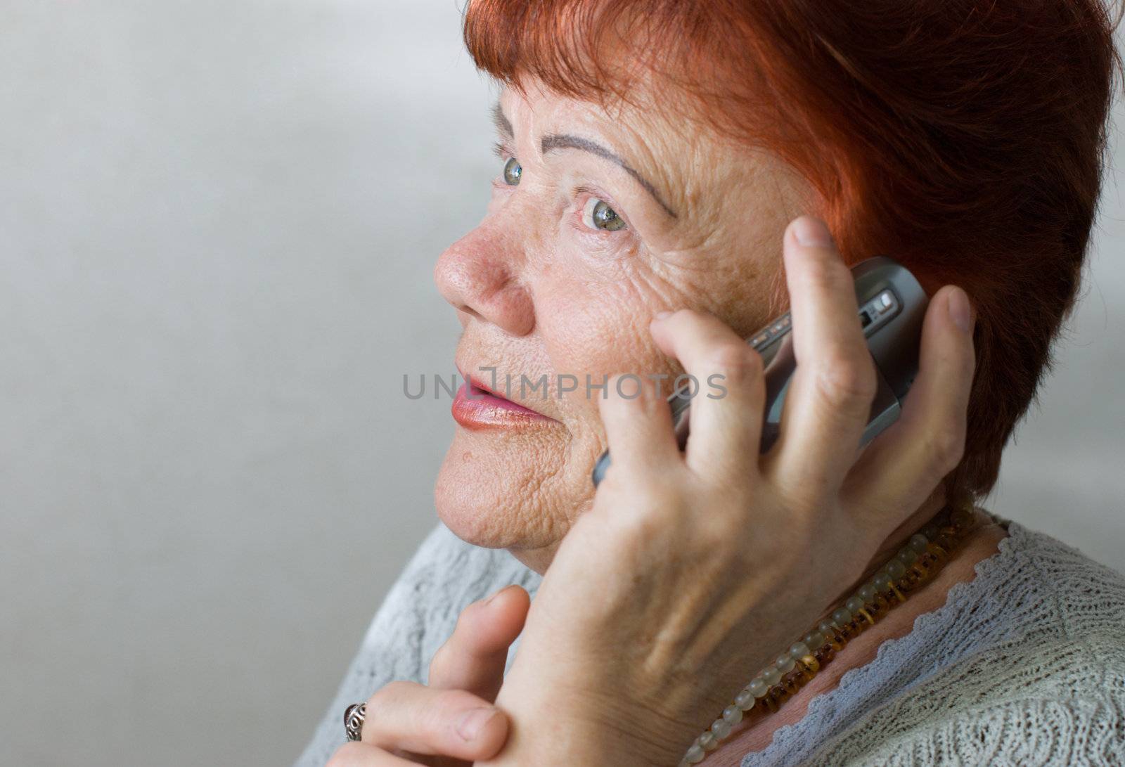 Seventy year old woman with cellphone by kzen