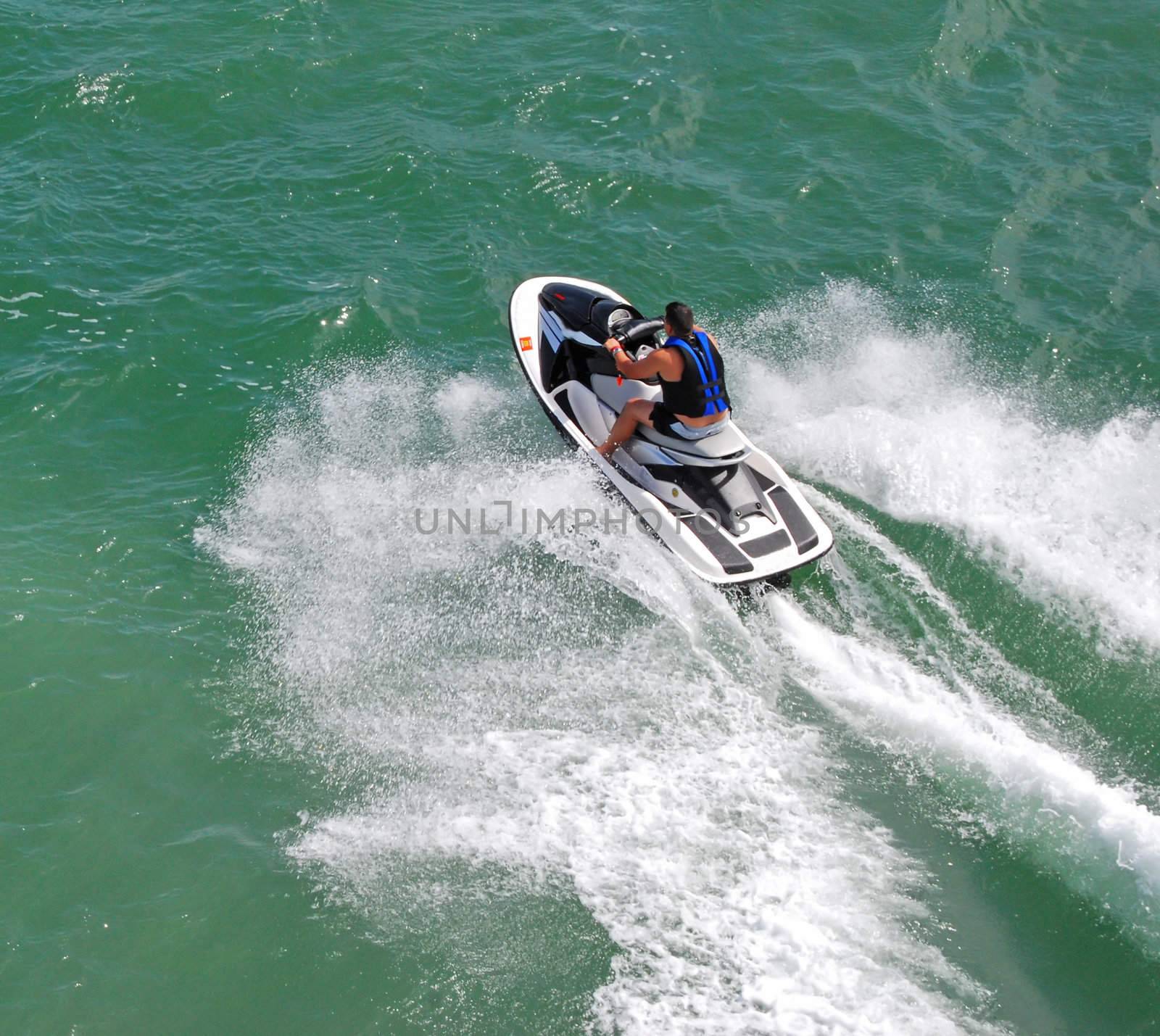 angled overhead view of a man going across biscayne bay near miami beach,florida on a jetski.
