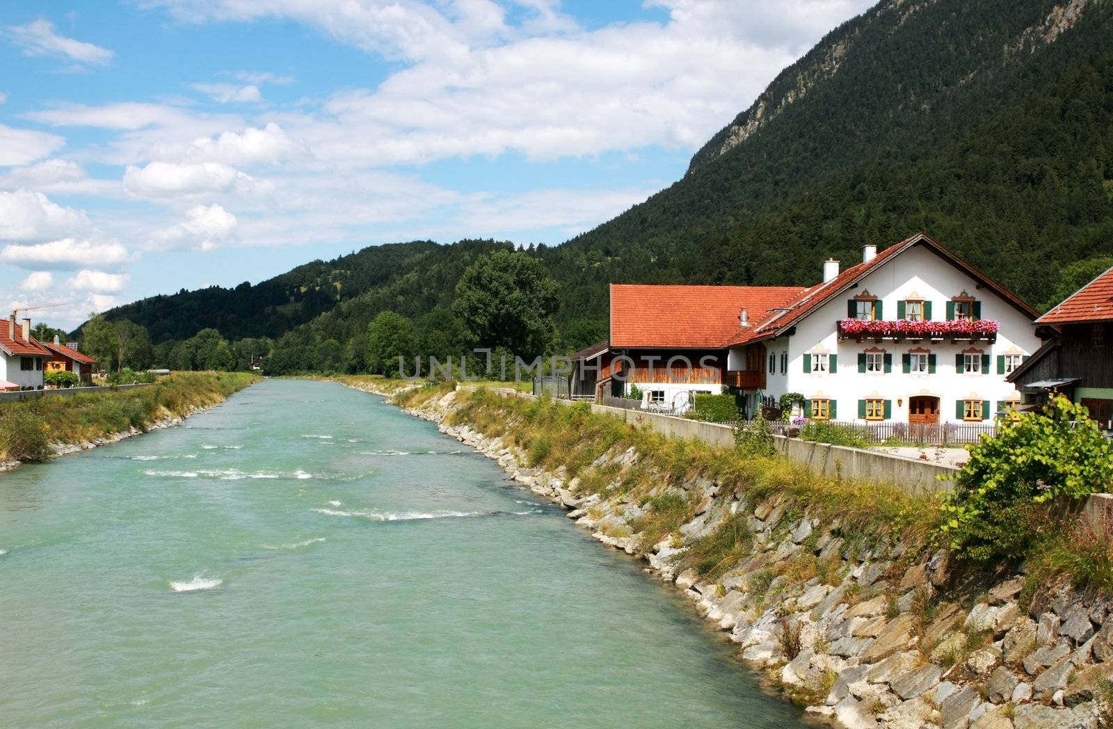 blue river and blue sky in small town next to Alps