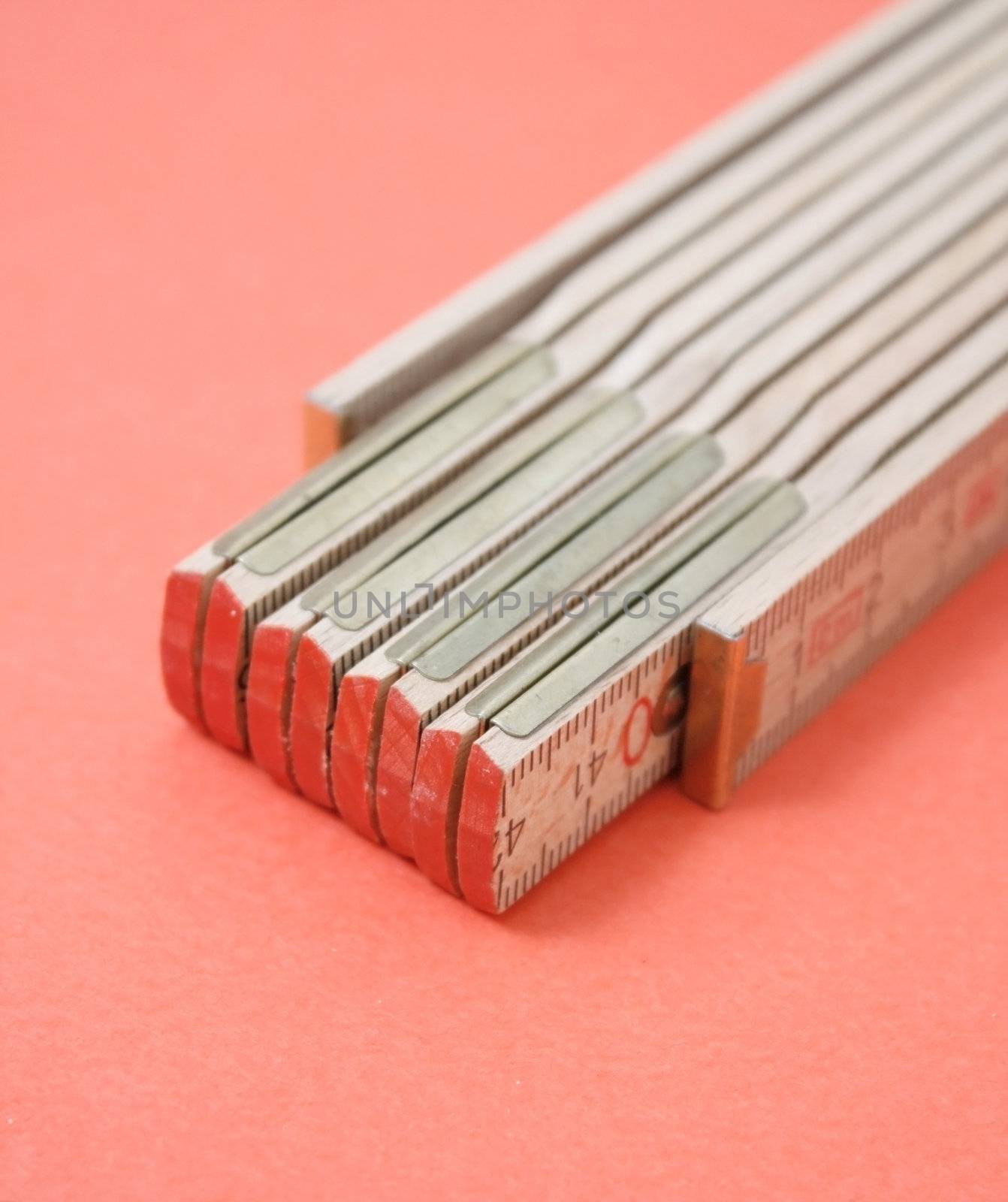 Wooden ruler isolated on red