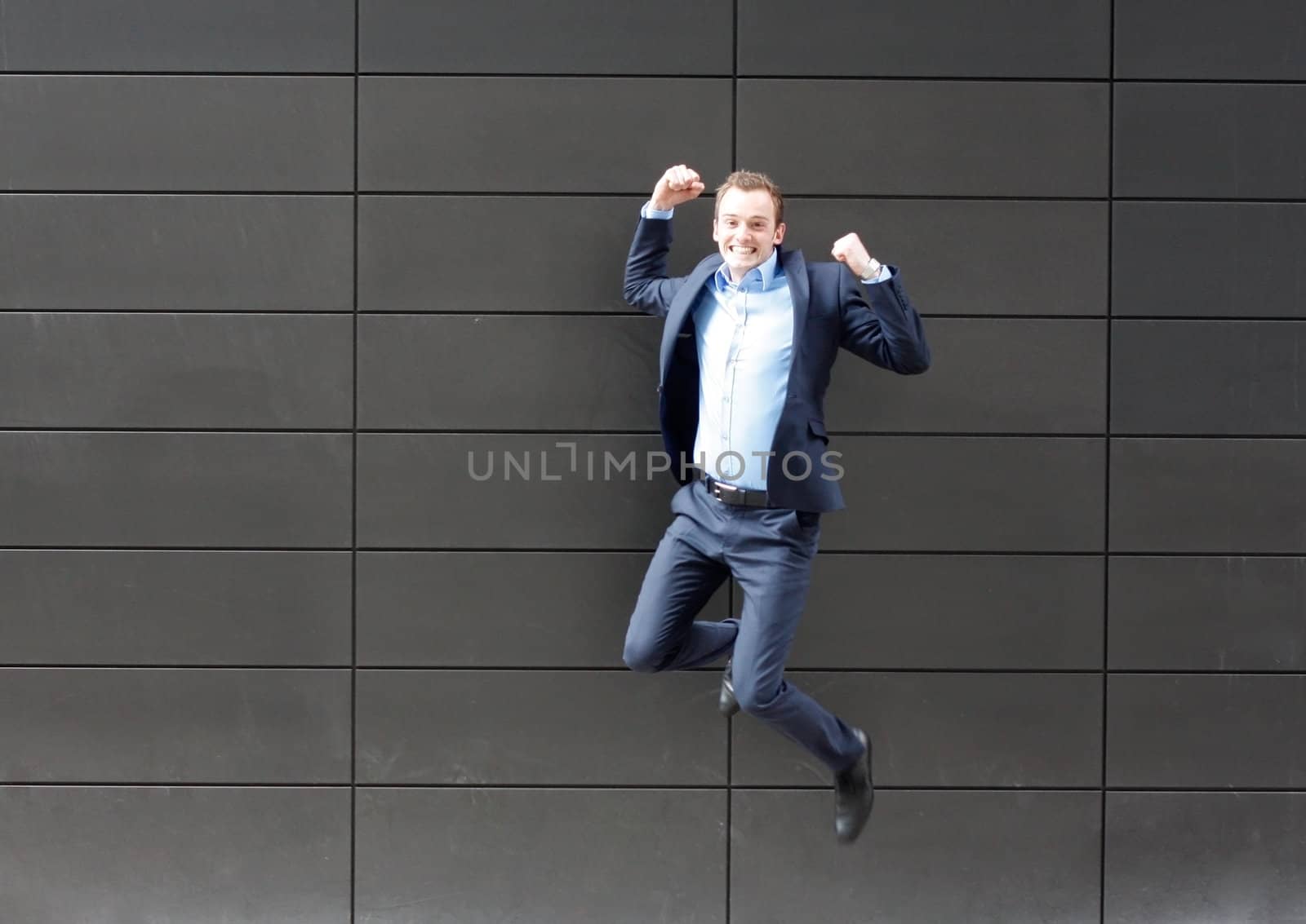 Business man jumping by leeser