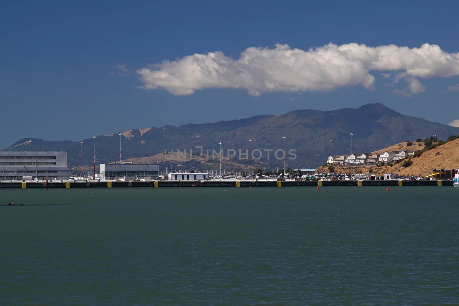 Wharf on sunny day with mountain on background