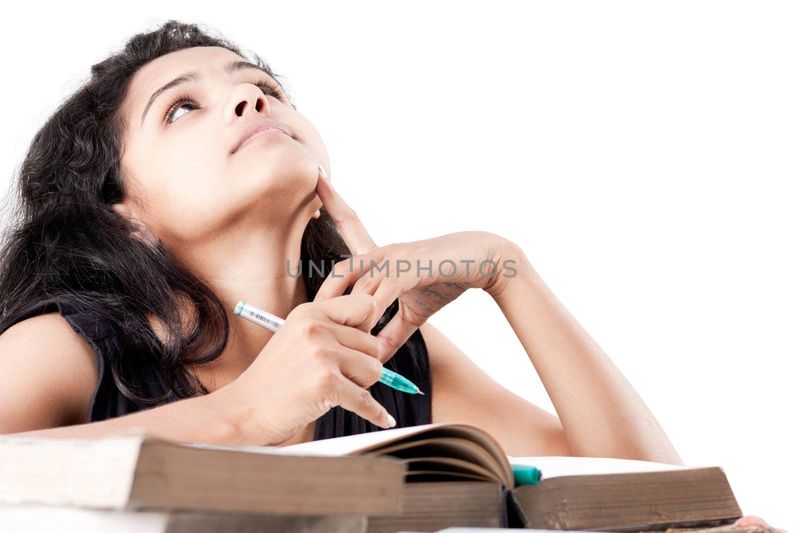 Tired and exhausted Young indian girl leaned over pile of  old books, isolated on white