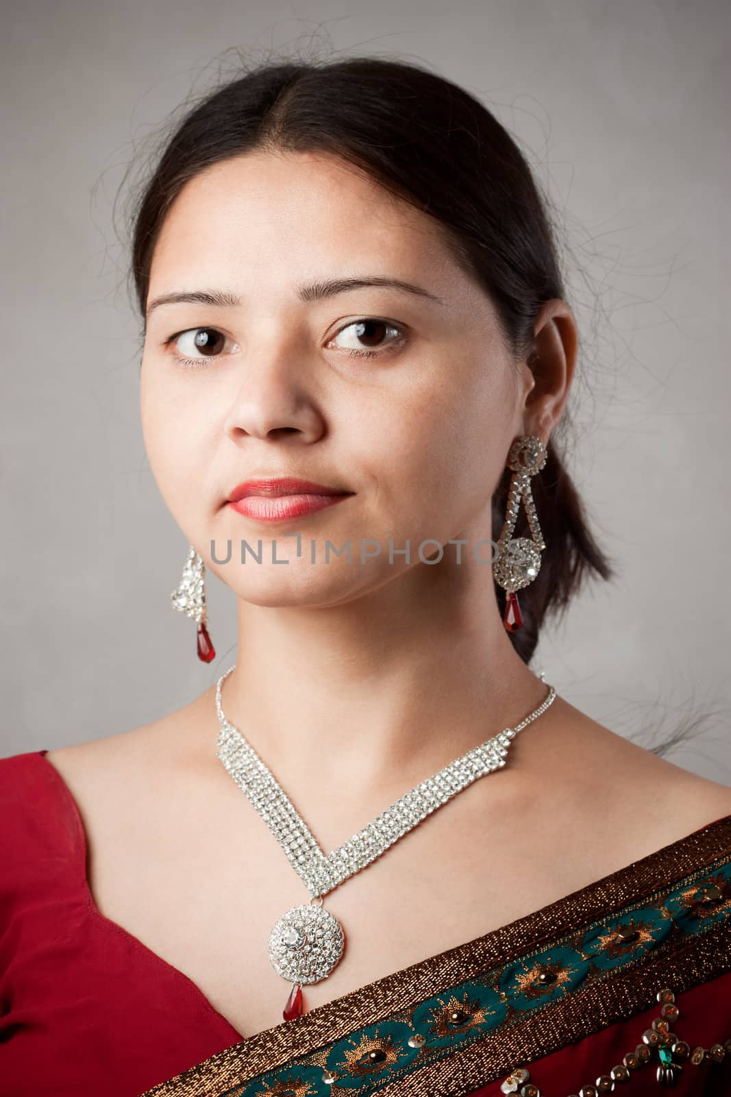 Smiling Indian happy woman wearing  beautifully embroidered red sari