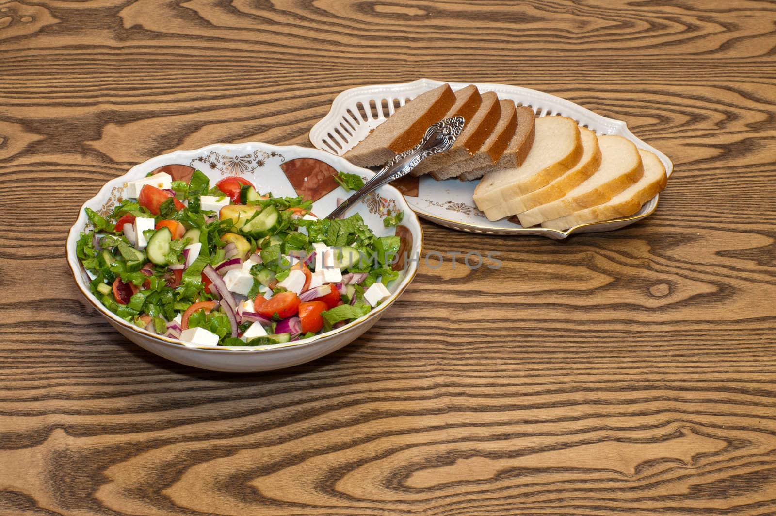 Greek salad and bread on the table.