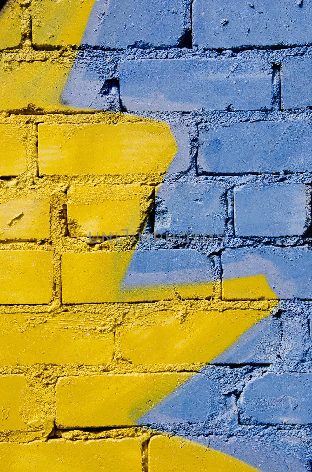 White brick wall colored yellow and blue. Nice background.