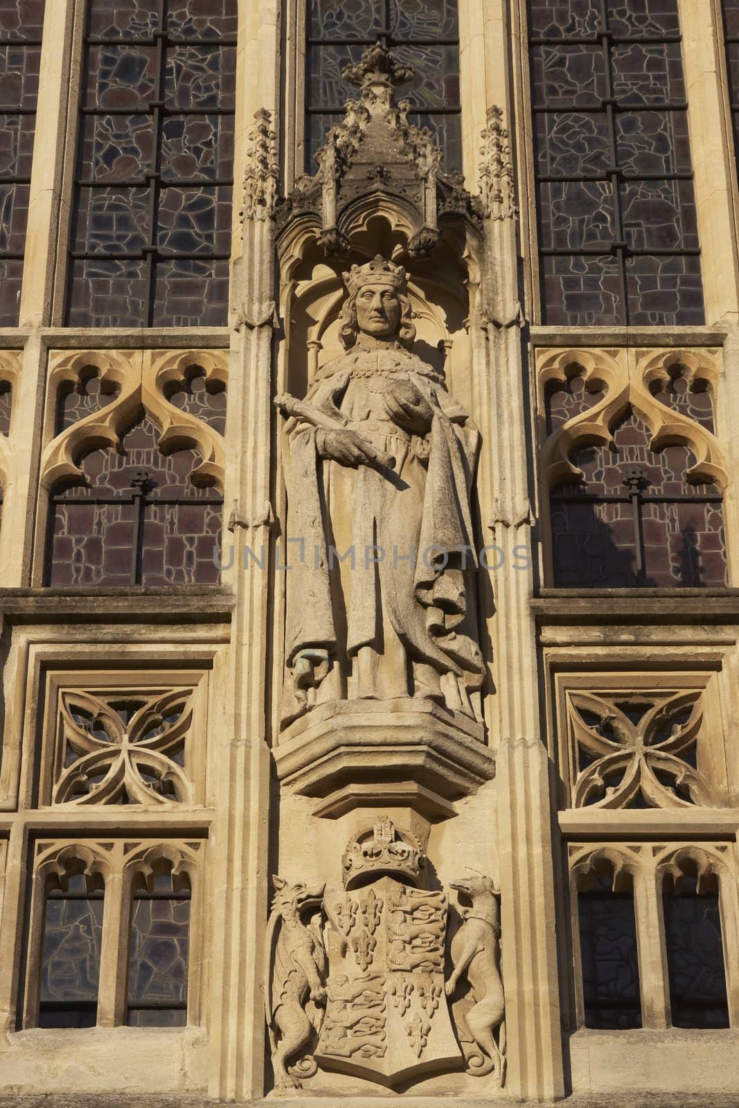 Religious statue decorating historic Bath Abbey in Bath, Somerset, England. Historic Georgian style building built of traditional honey colored sandstone.