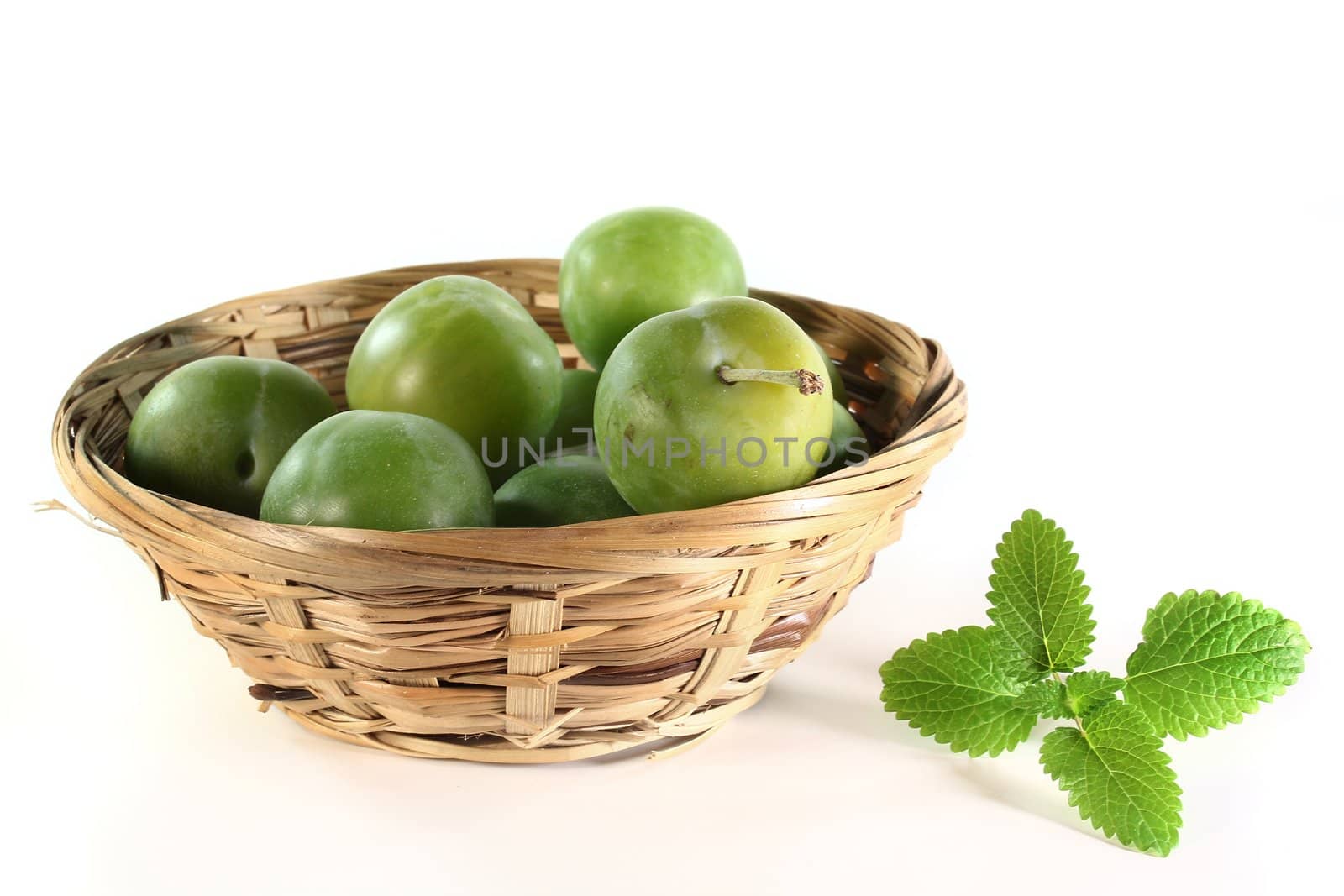 fresh green plums on a white background