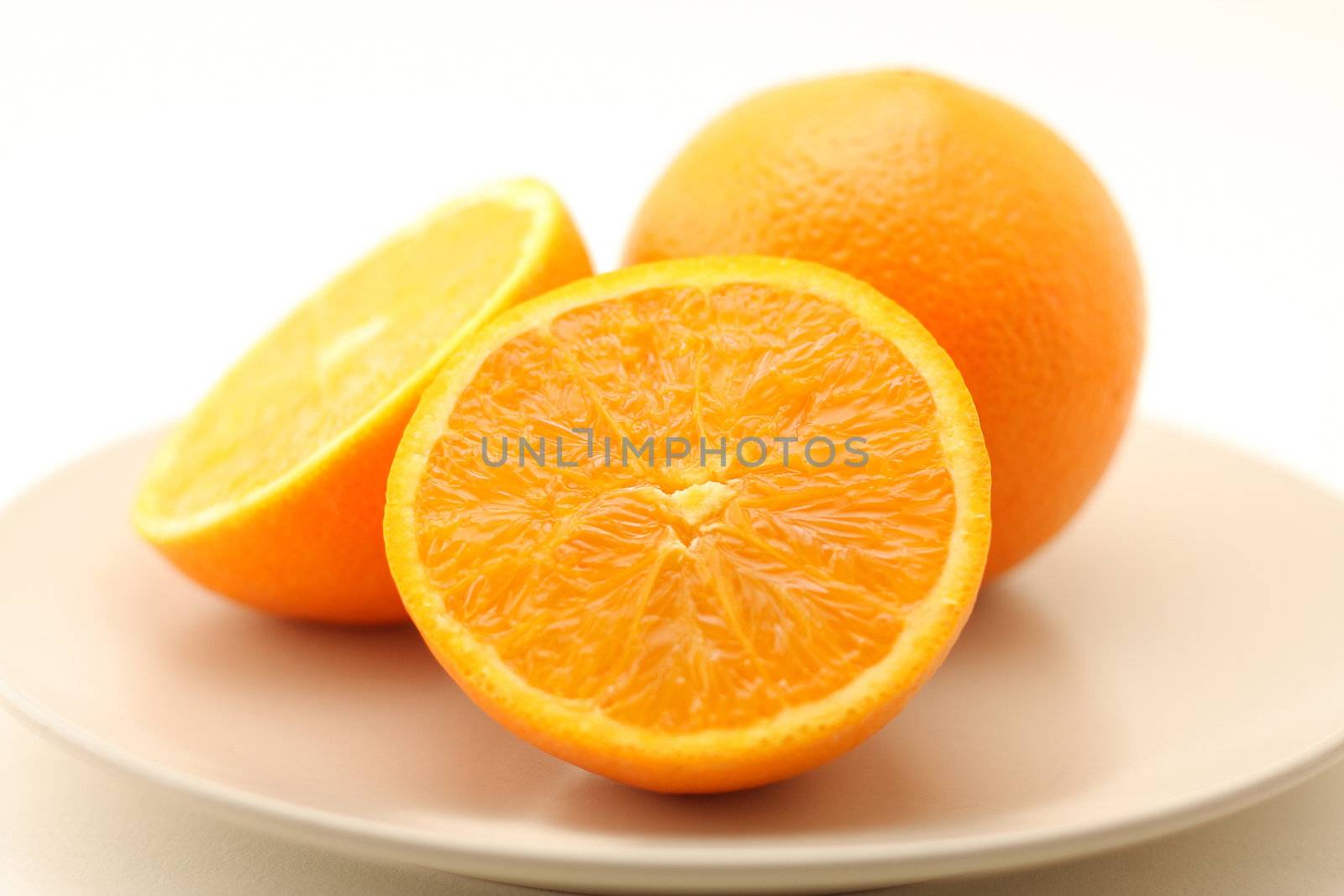 Oranges on plate isolated on white background by svanblar