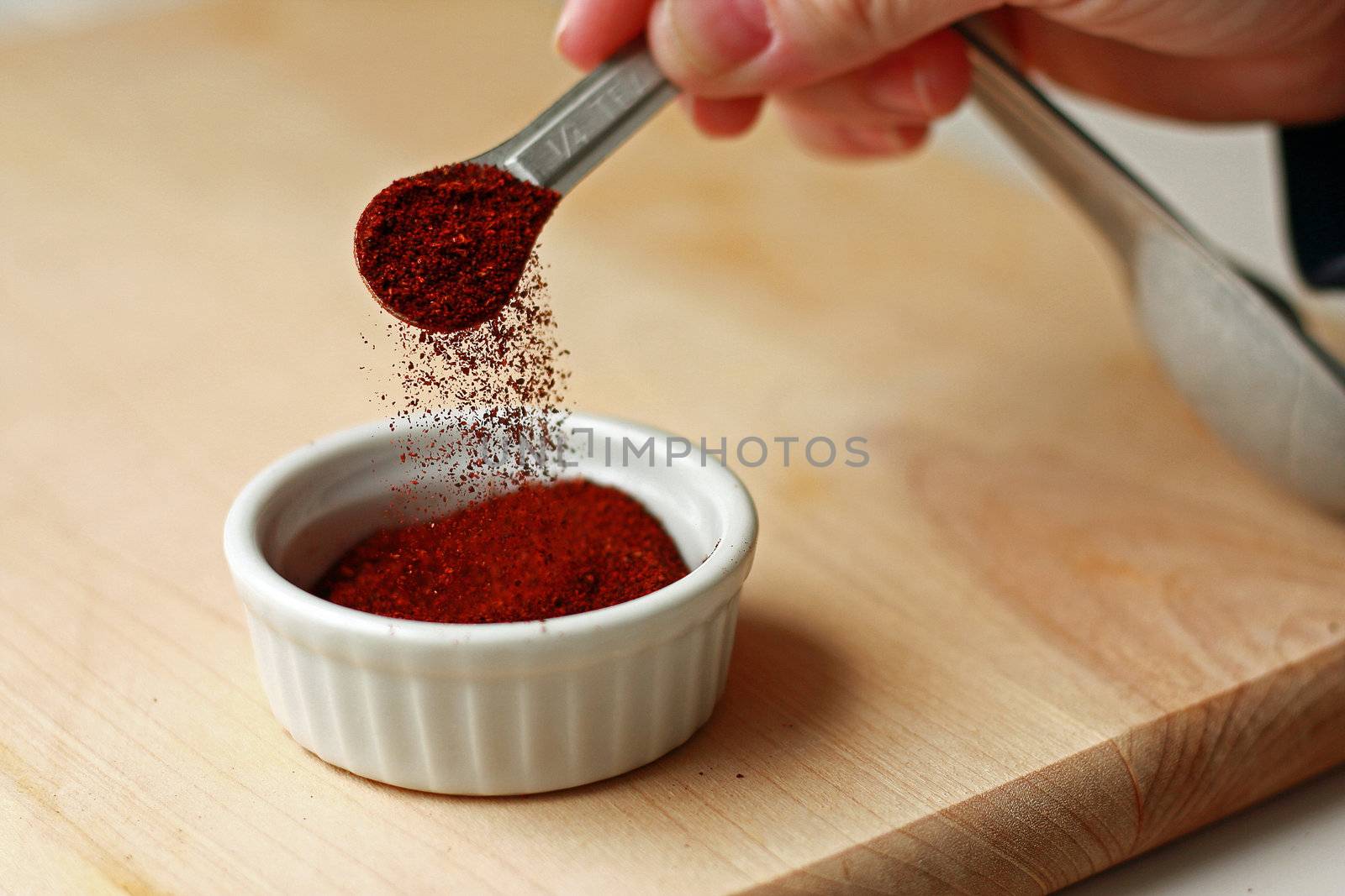 Spice measured with measuring spoon on cutting board by svanblar