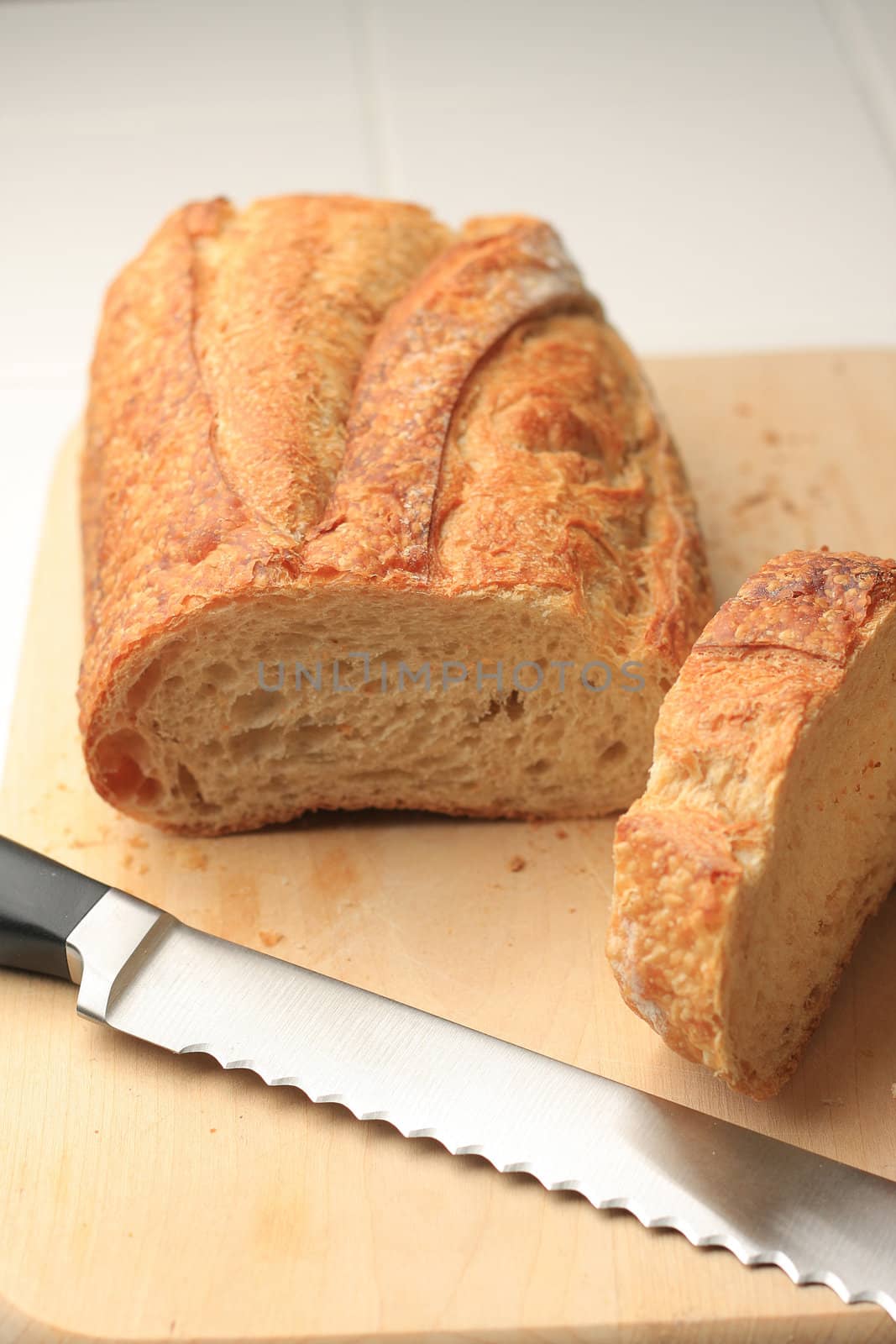 Loaf of bread on cutting board with knife