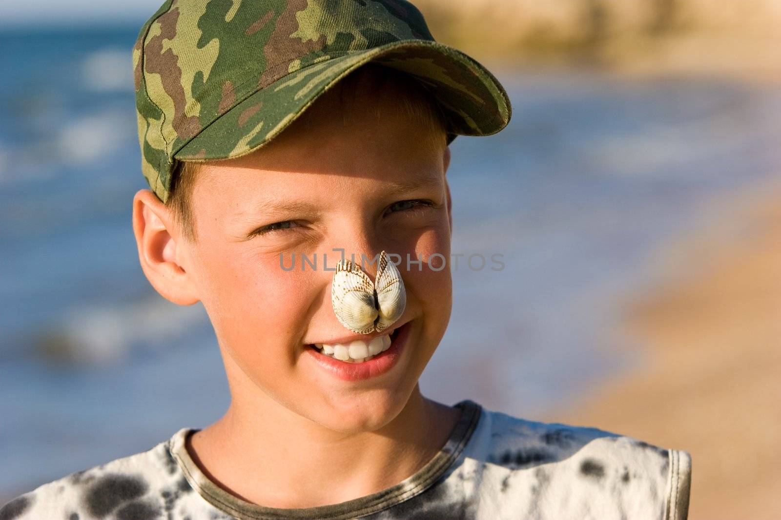 portrait series: a summer cheerful boy with sea shell