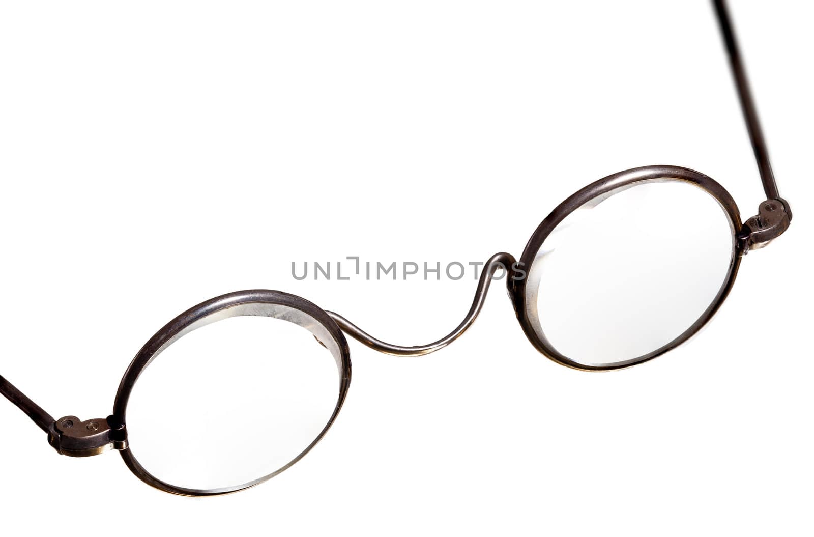 Old fashioned round reading glasses laying on a a white background and isolated