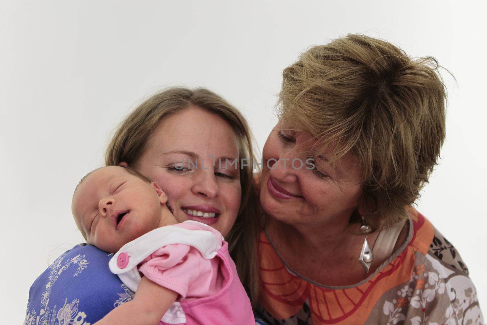 Females of three generations, Grandmother Mother and daughter all together smiling front of the white background.