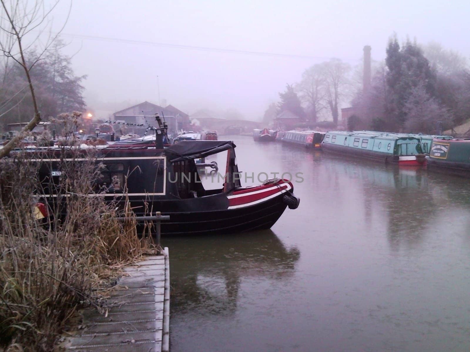 A canal boat on a frozen canal at Braunston, Northamptonshire