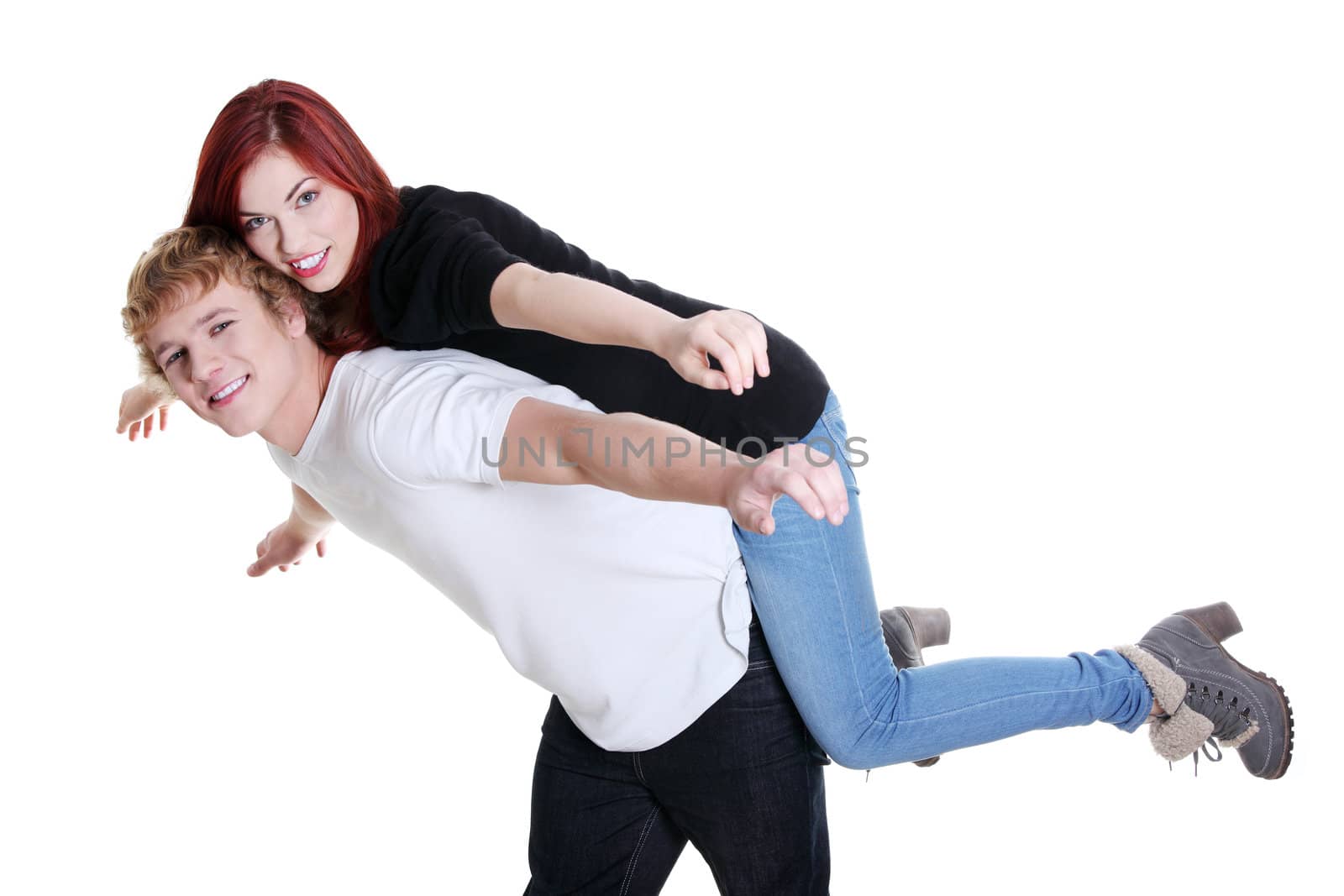 Young beautiful smiling couple having fun together with piggyback ride and arms outstretched. Isolated on white background.
