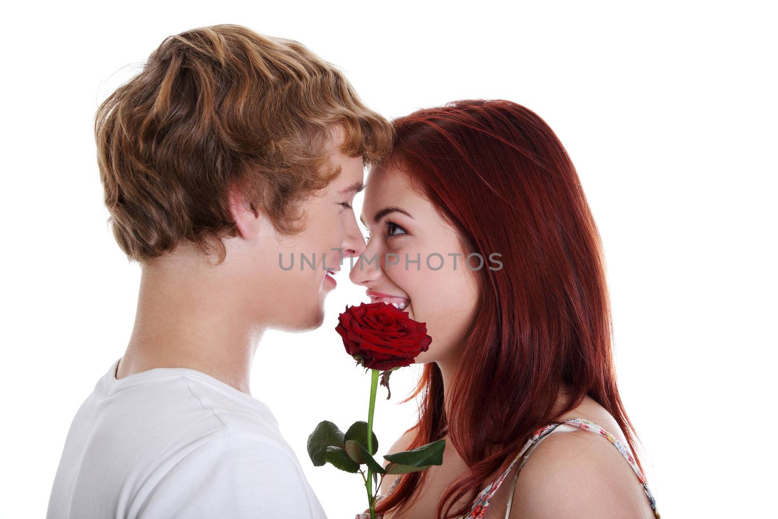 Young caucasian couple holding red rose, isolated on white background.