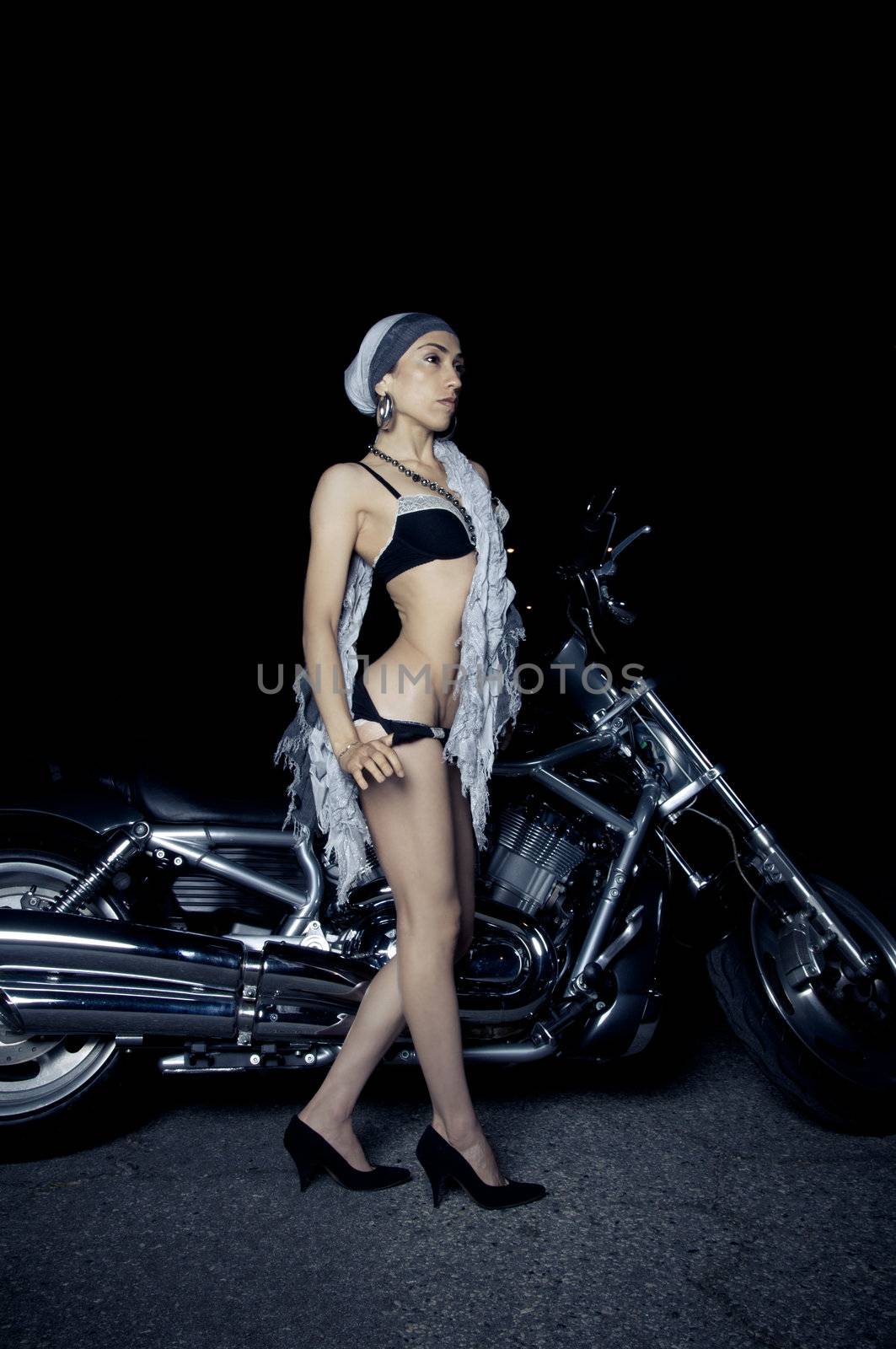 Beautiful biker model posing with motorcycle