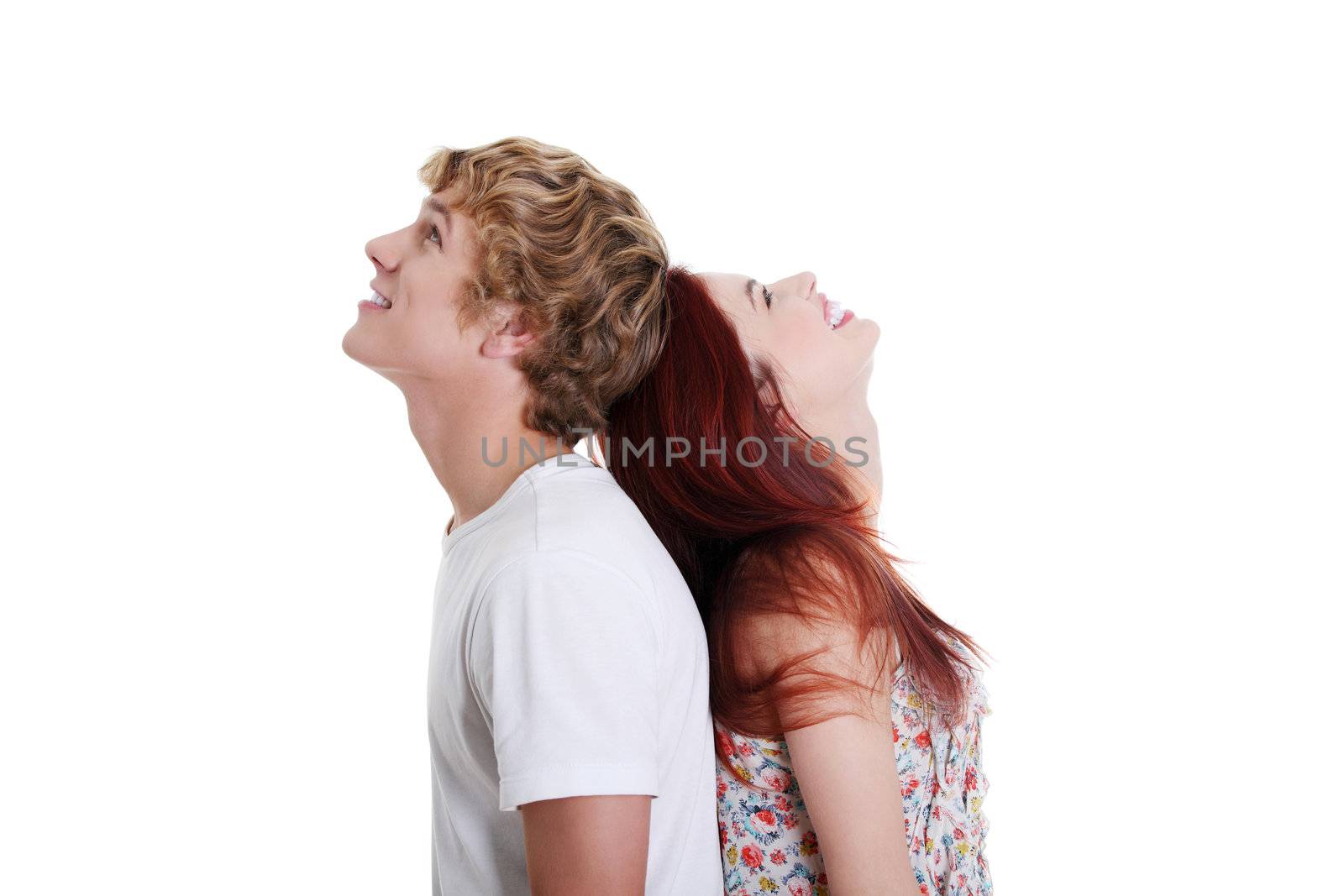 Portrait of a smiling young couple standing back to back, isolated on white background.