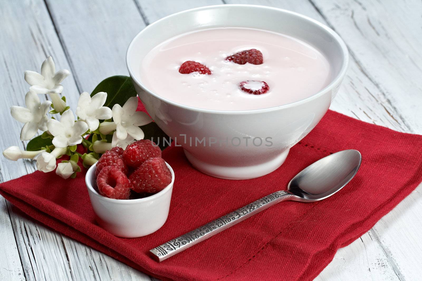 some fresh seasonal summer raspberries with yogurt