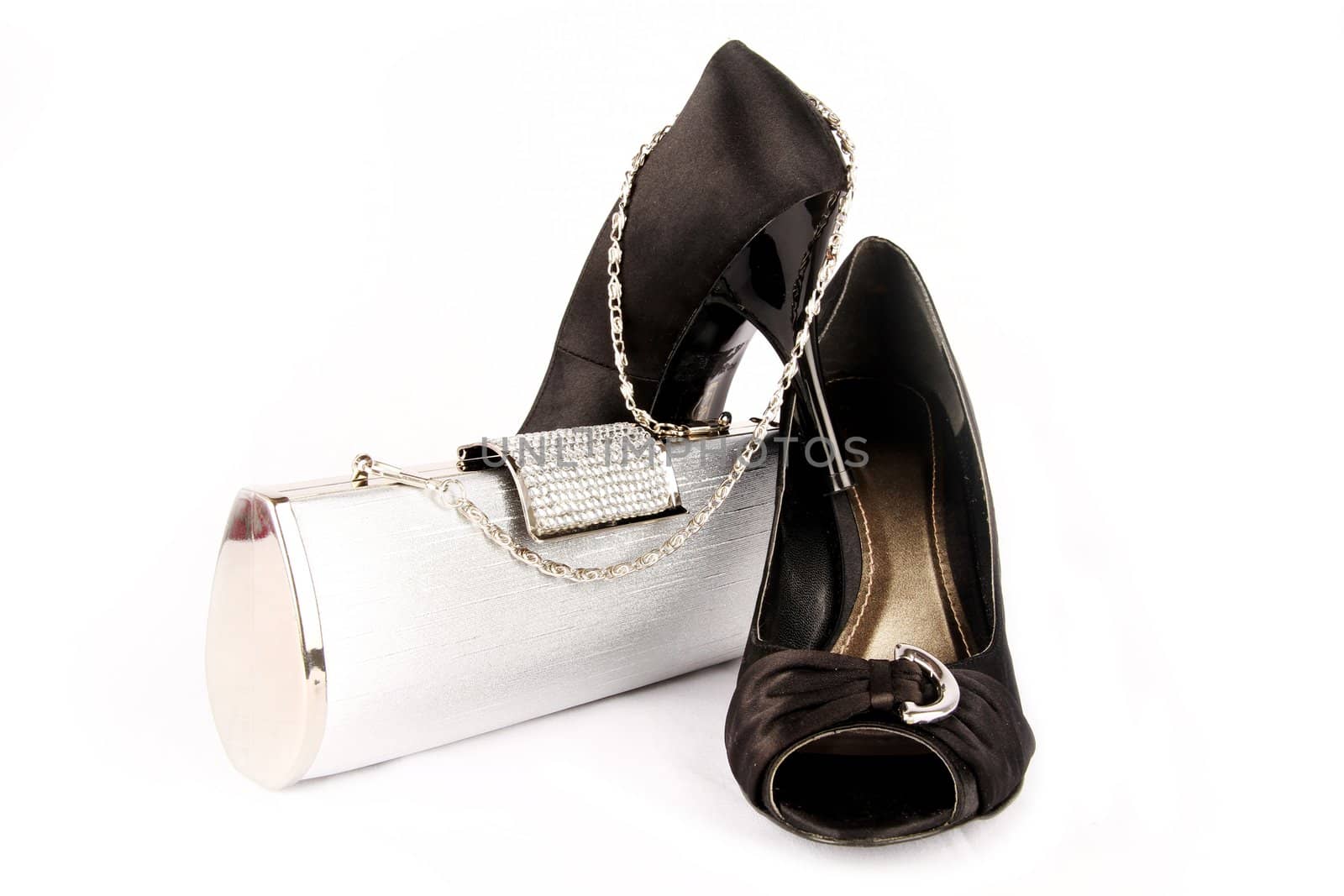 Black high heel women shoes and a silver clutch on white background.