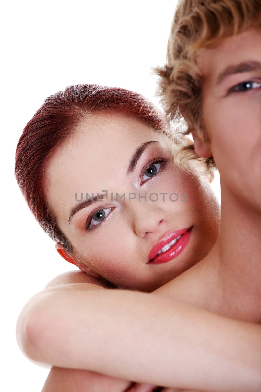 Closeup on young caucasian topless couple embracing over white background.