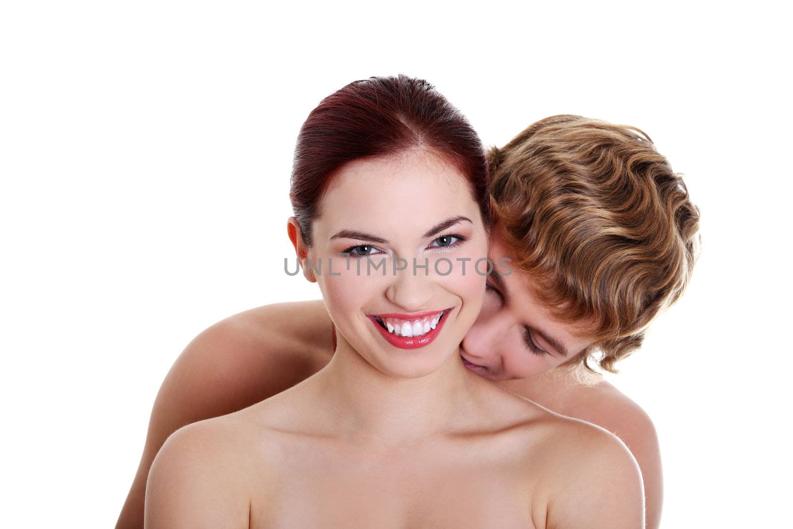 Topless caucasian boy kissing his pretty naked girlfriend. Isolated on white background.