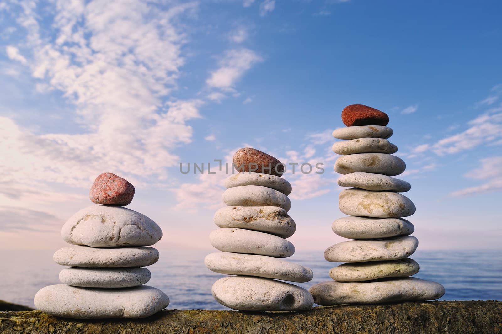 Three piles of pebbles. With red stone on the top
